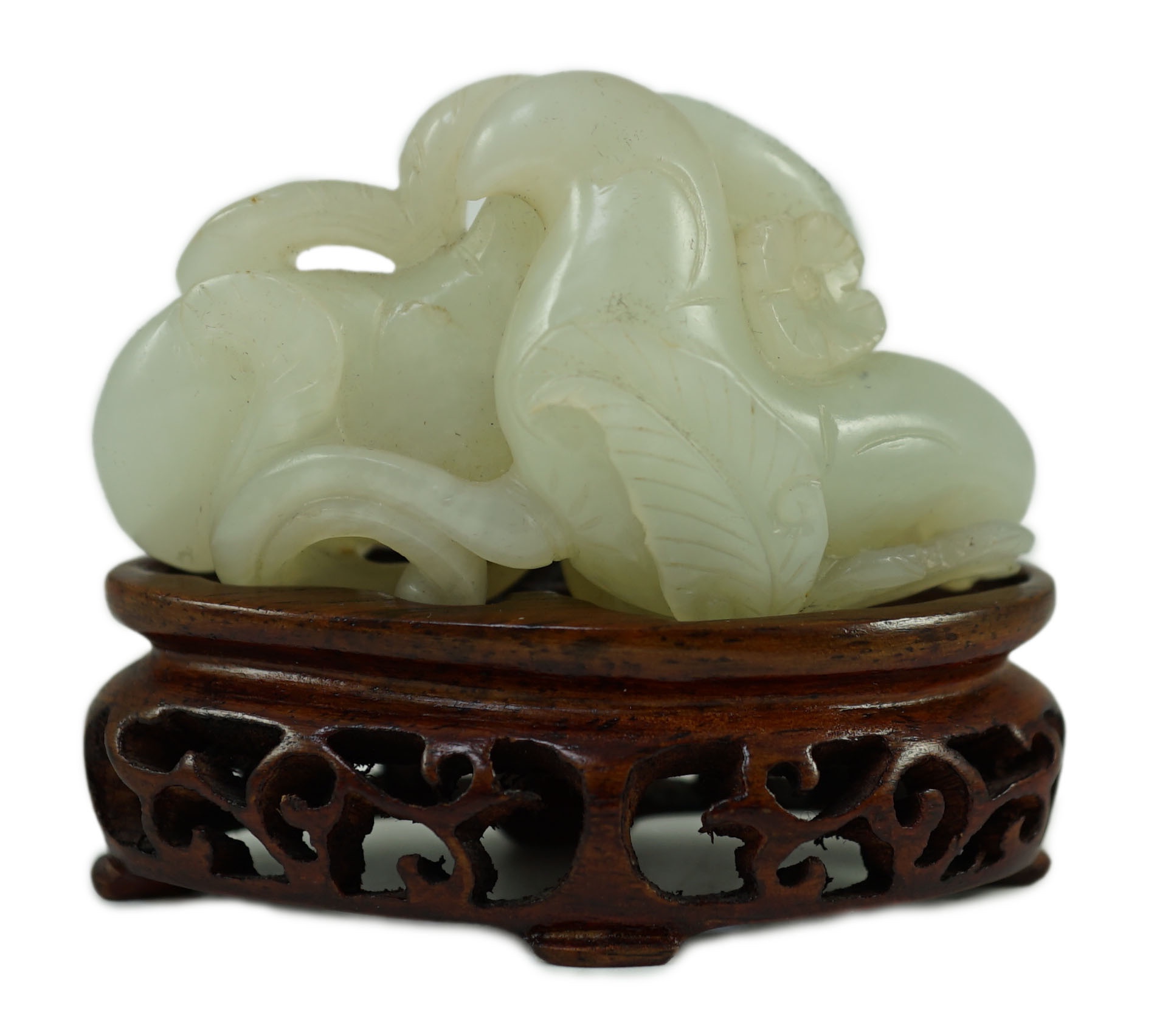 A Chinese pale celadon jade ‘Lotus’ pebble carving, 18th/19th century, 6.2 cm wide, wood stand                                                                                                                              