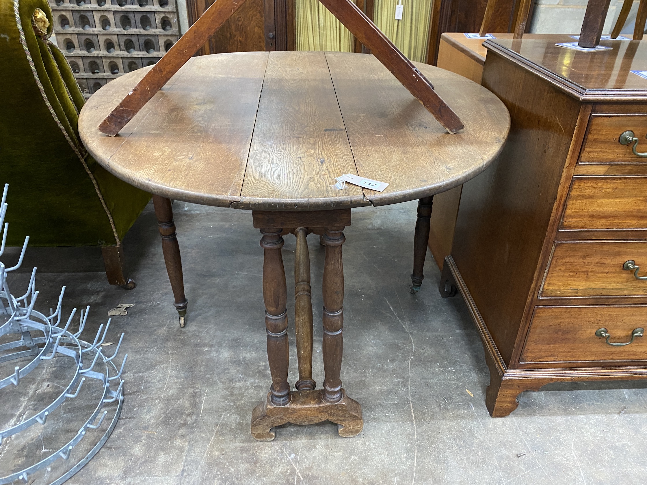 An early 20th century oak drop flap dining table, width 116cm, depth 98cm extended, height 70cm                                                                                                                             