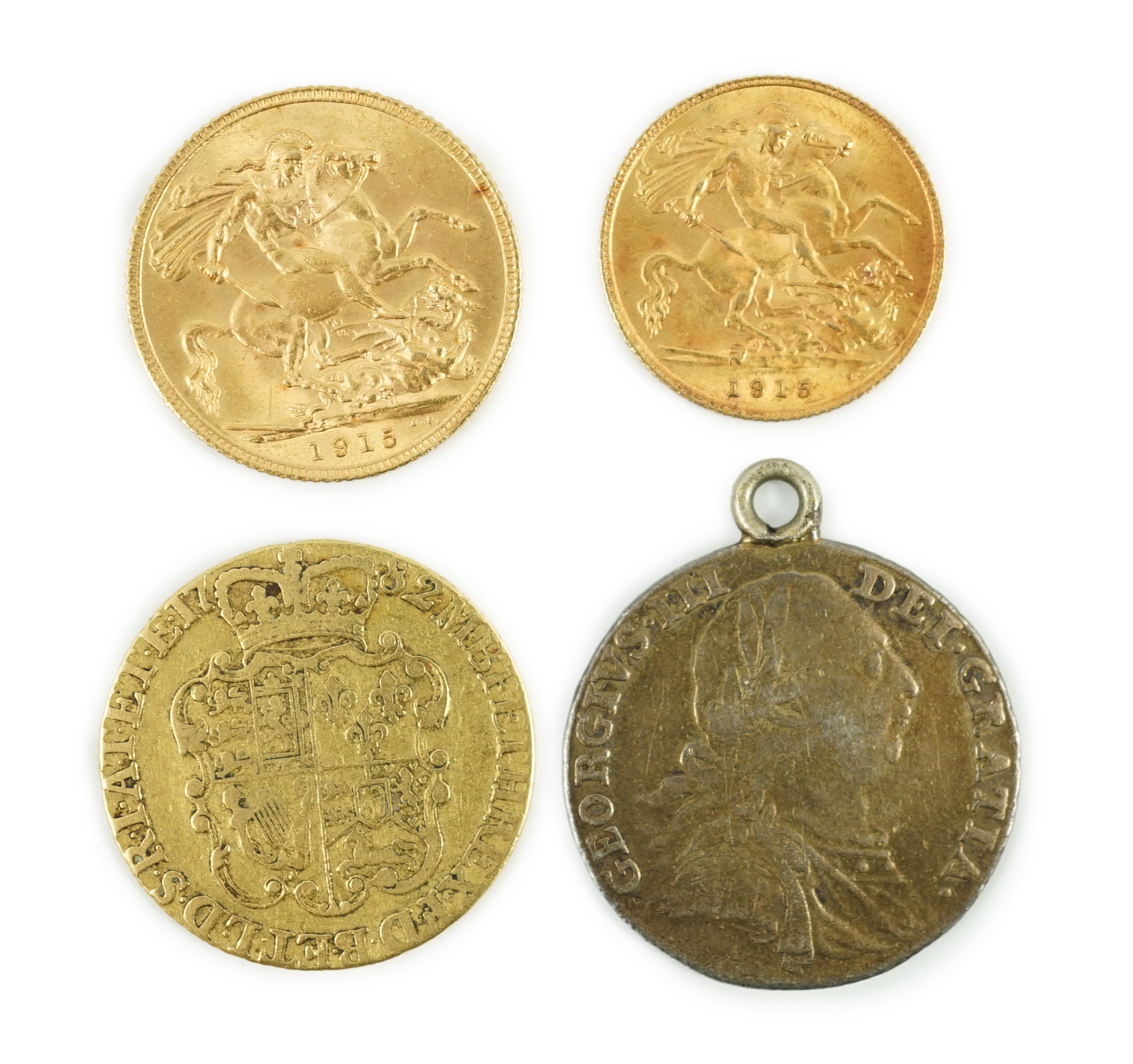 A George V 1915 gold sovereign and a 1915 gold half sovereign, a George III 1782 gold guinea(worn) and a George III 1787 shilling, with pendant mount.                                                                      