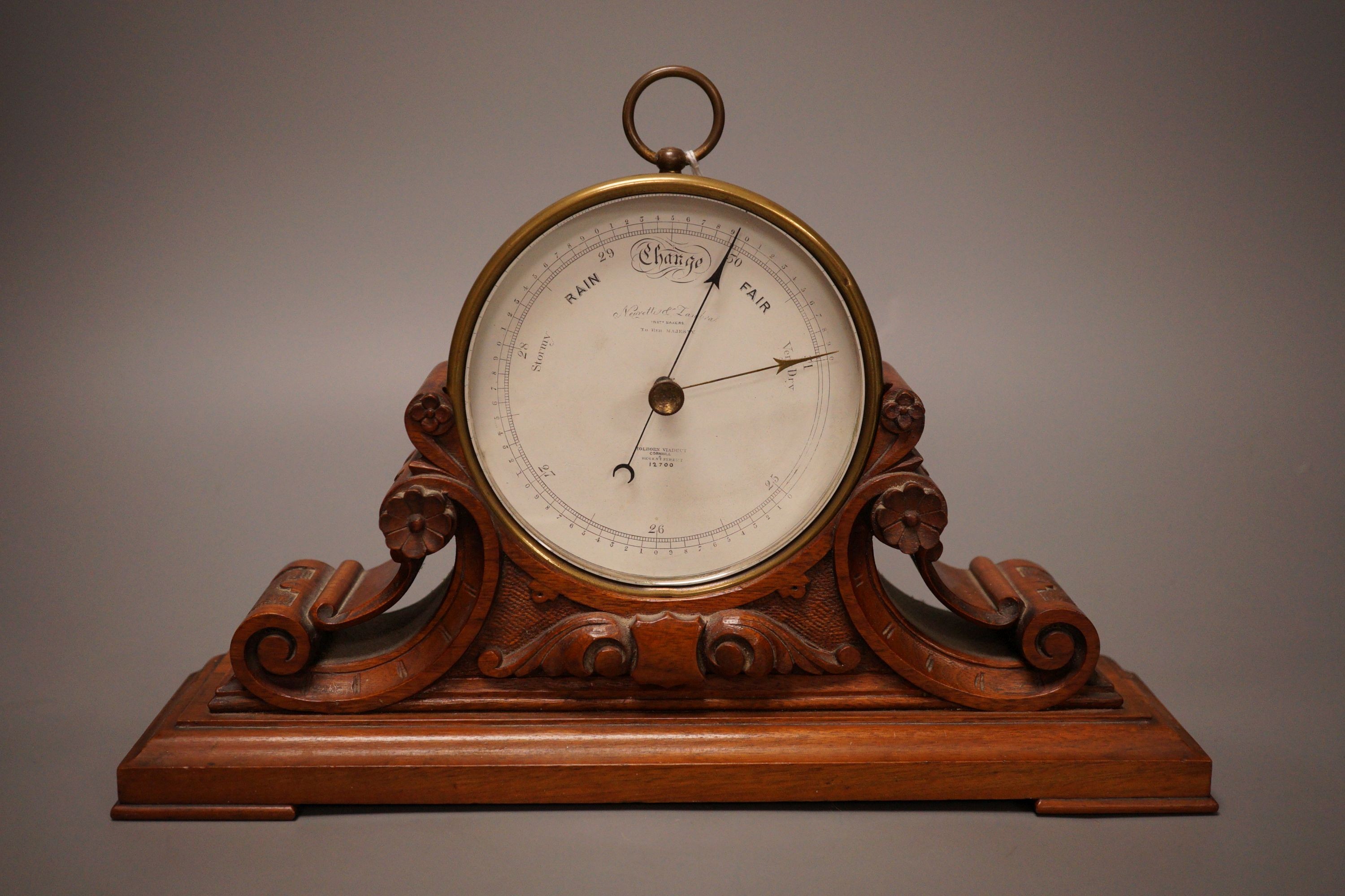 A Negretti & Zambra brass cased barometer on carved walnut stand, 31cm wide                                                                                                                                                 