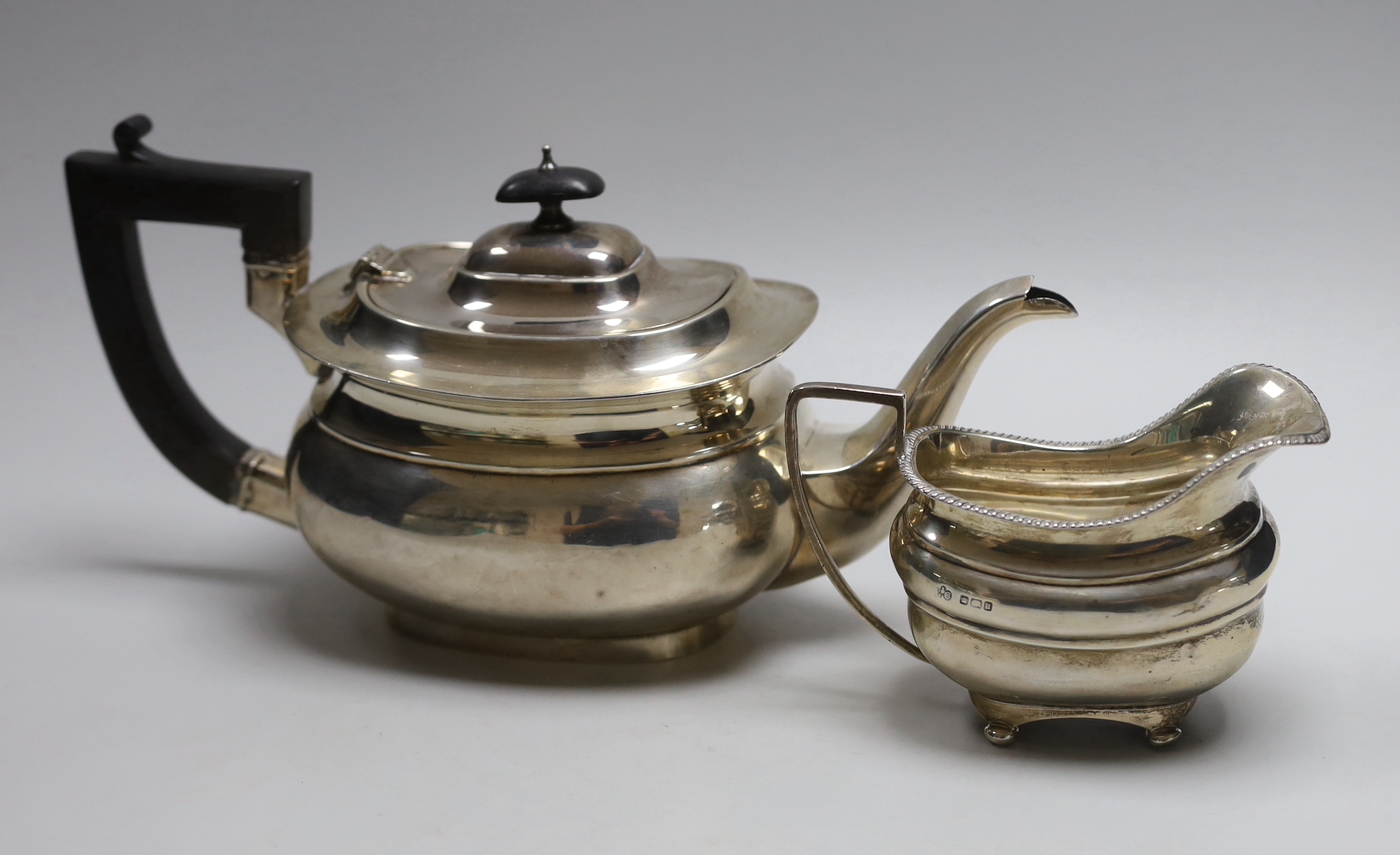 A George V silver teapot, Birmingham, 1921 and a George V silver cream jug, Elkington & Co, Sheffield, 1912, gross weight 24.3oz.                                                                                           