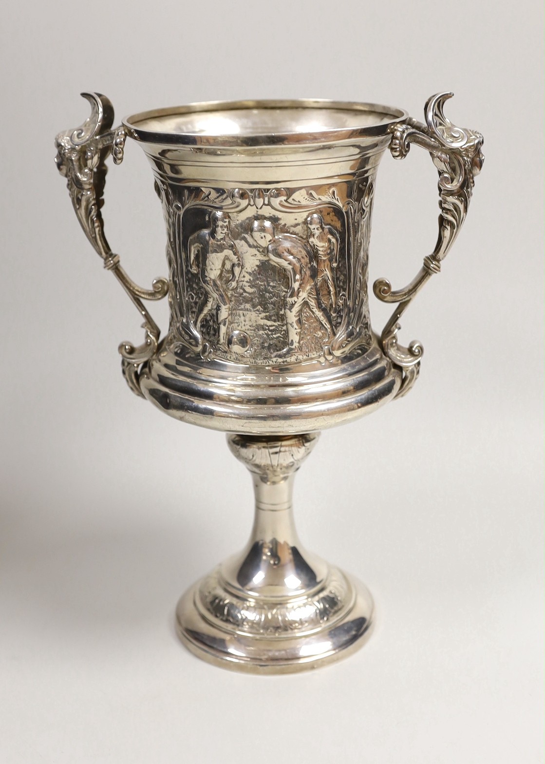FOOTBALL INTEREST- A late Victorian silver two handled presentation trophy cup, embossed with footballers and inscribed ' Vernon Wentworth Challenge Cup, presented top The Brighton Football Association by Bruce c. Vernon