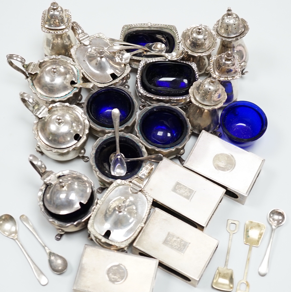 A George V six piece silver condiment set by Mappin & Webb, assorted other condiments including three silver and four silver matchbox sleeves.                                                                              