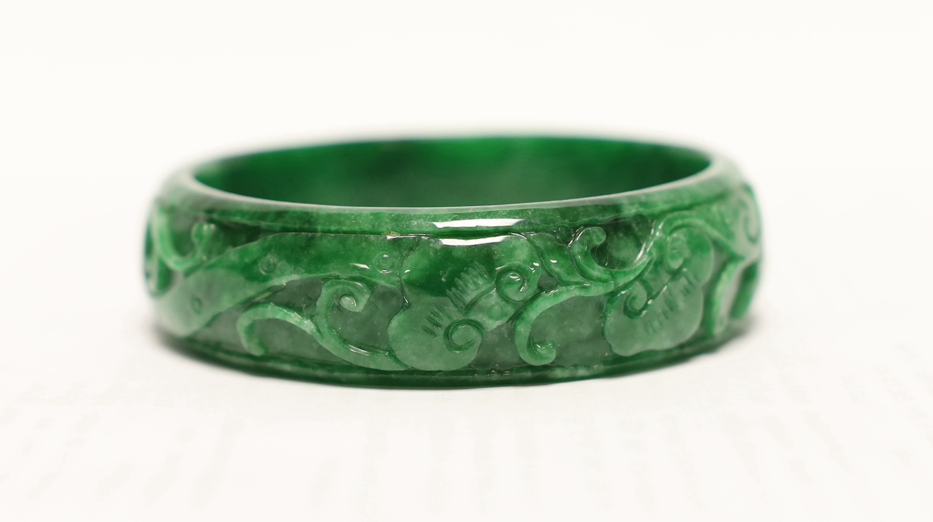 A Chinese carved jadeite bangle, 7.5cm in diameter                                                                                                                                                                          