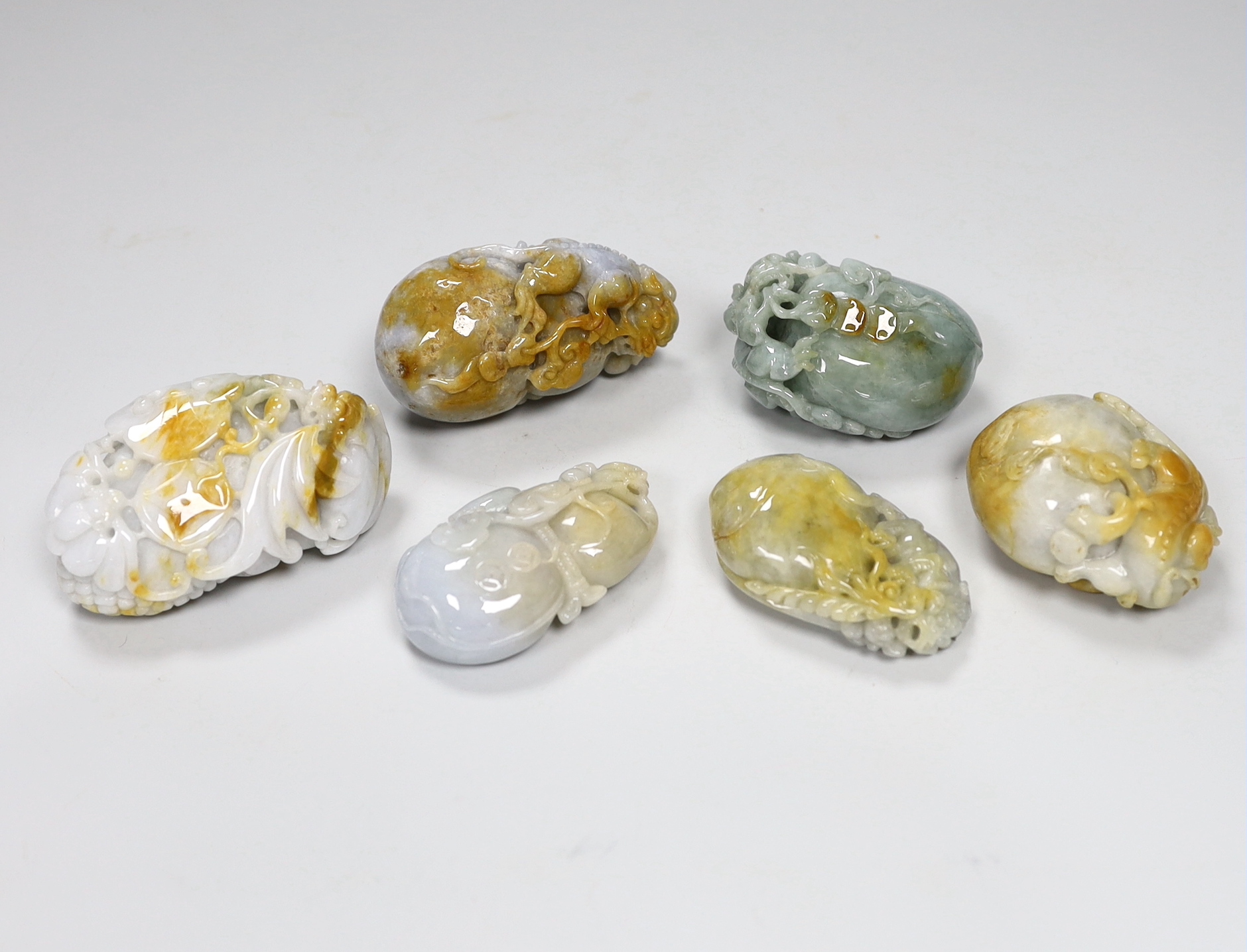 Six Chinese jadeite 'pebble' carvings including one of bars and fruit, 8cm wide                                                                                                                                             