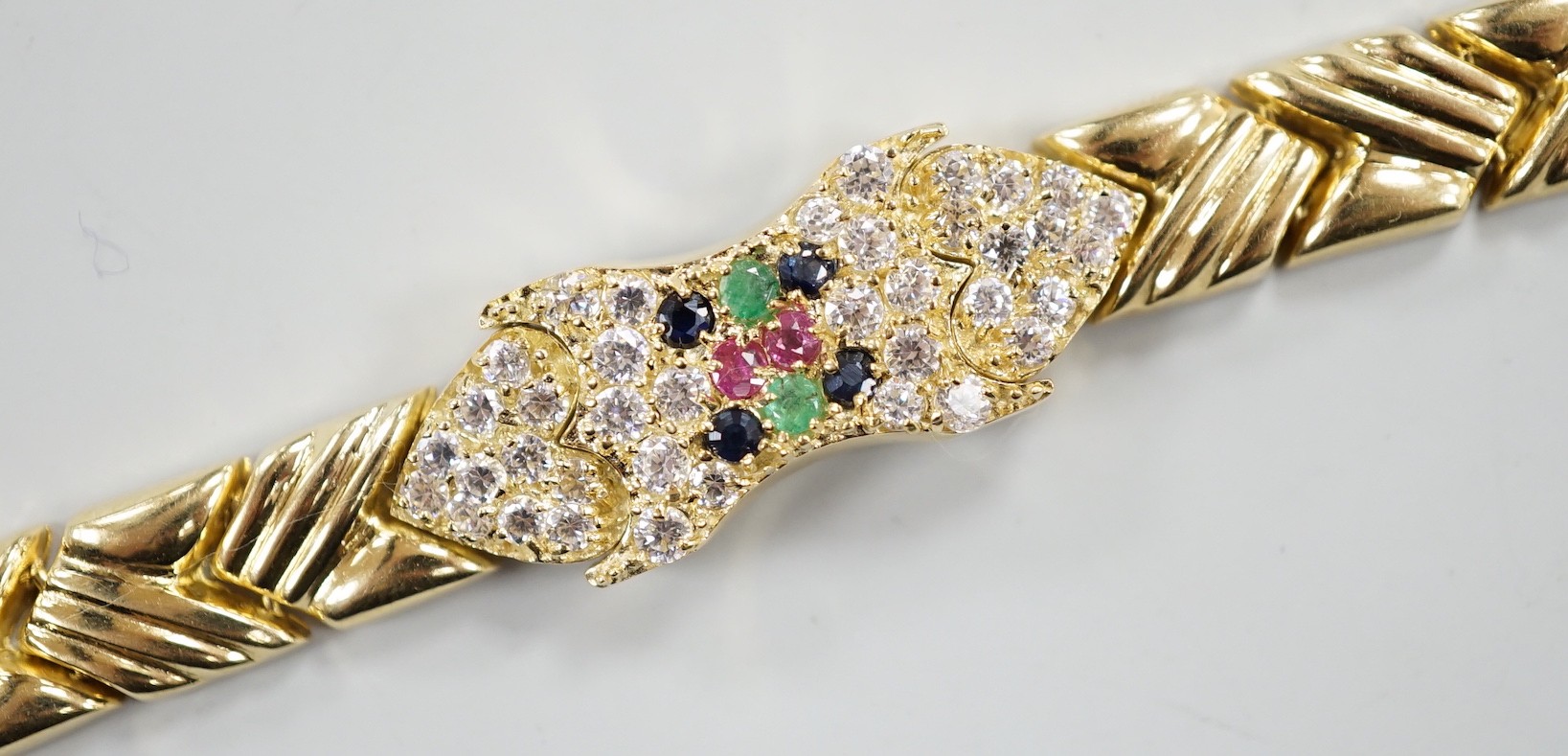 A modern 585 yellow metal, ruby, sapphire, emerald and diamond cluster set bracelet, 17.5cm, gross weight 18.9 grams.                                                                                                       