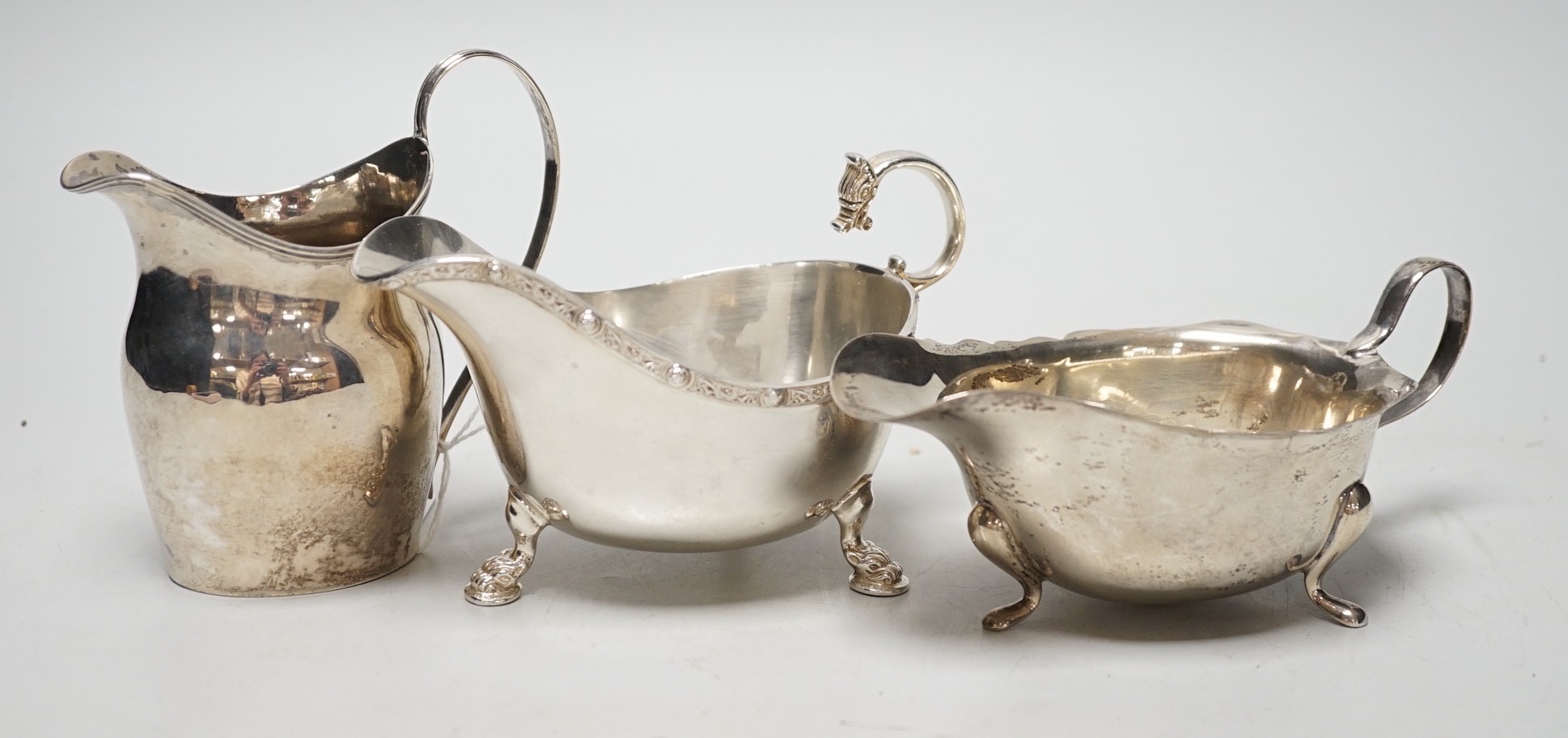 A George III silver cream jug, London, 1801, height 11cm, together with two later silver sauceboats, 10.9oz.                                                                                                                