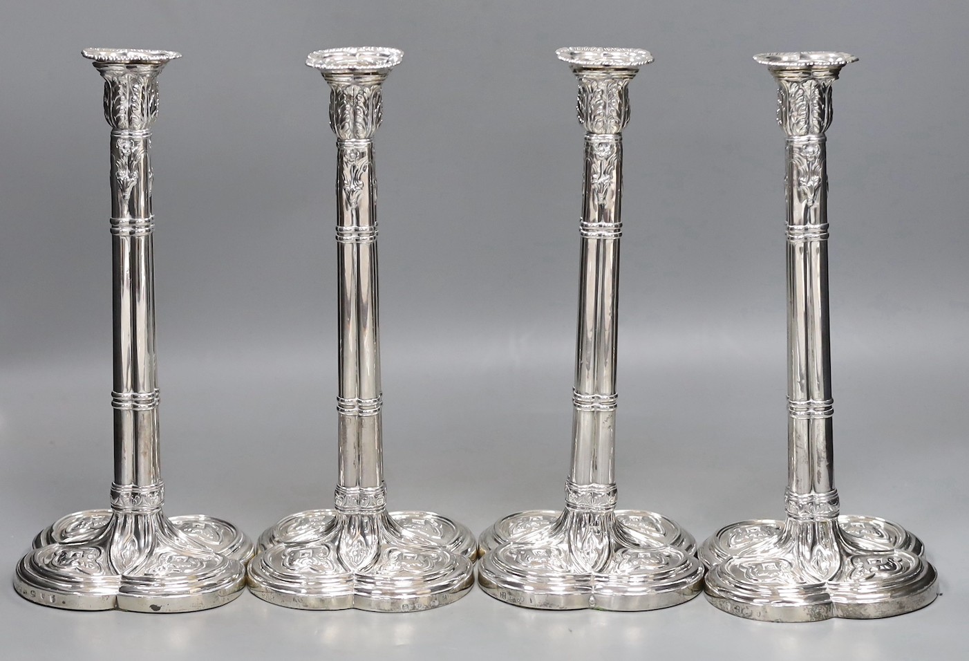 A set of four early George III silver gothic cluster column candlesticks, on cusped quatrefoil bases, by Hannam or Hammond & Carter, London, 1763, 28.8cm, weighted (holes).                                                