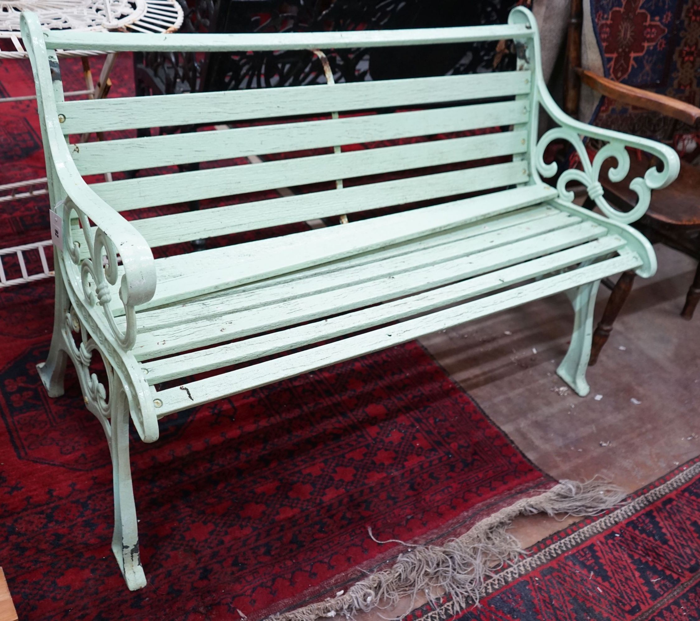 A Victorian style painted cast iron slatted garden bench, in need of restoration, length 128cm, depth 60cm, height 80cm                                                                                                     