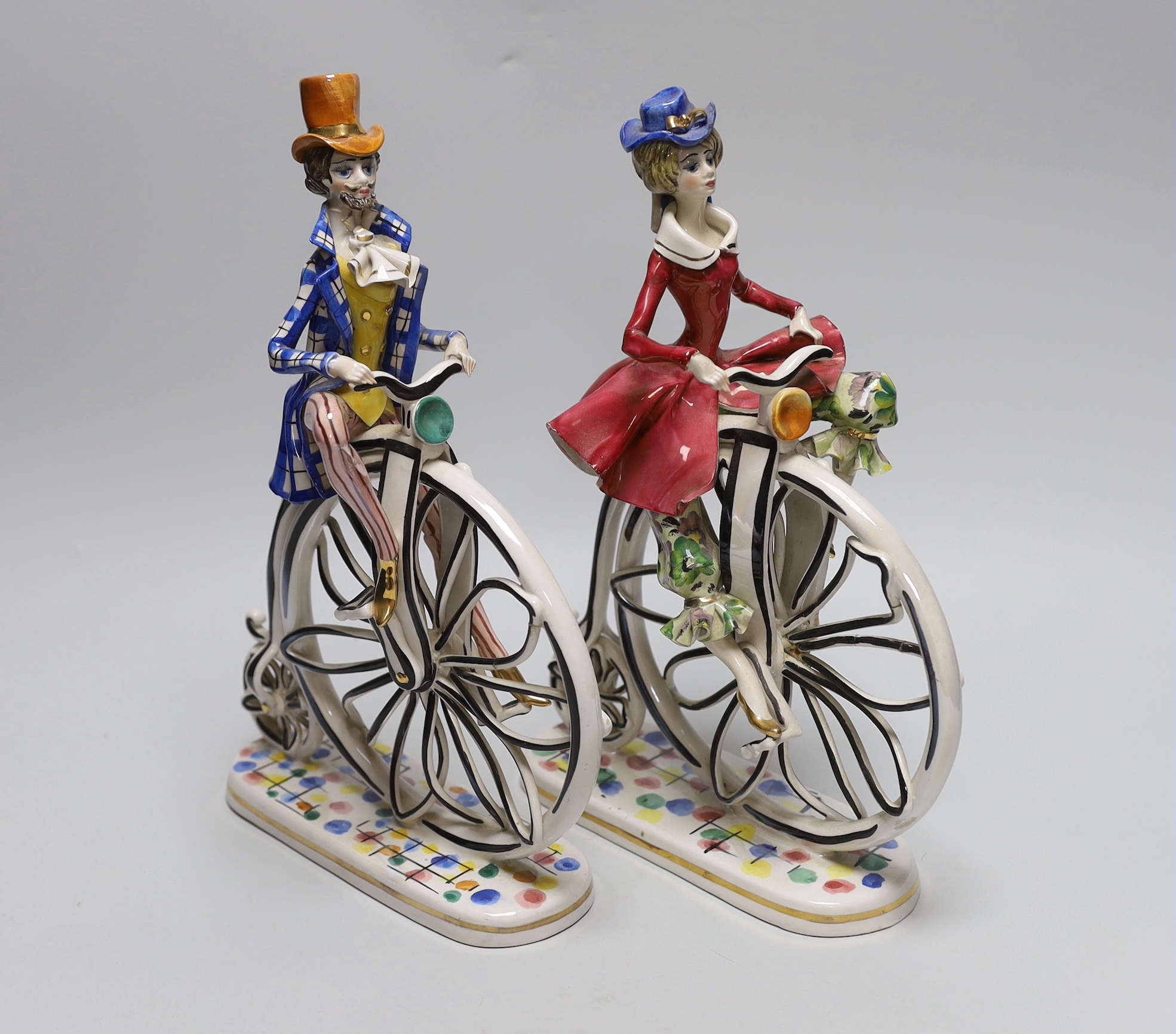 A pair of 1950’s- 60’s Italian ceramic penny farthing cyclists, 31cm                                                                                                                                                        