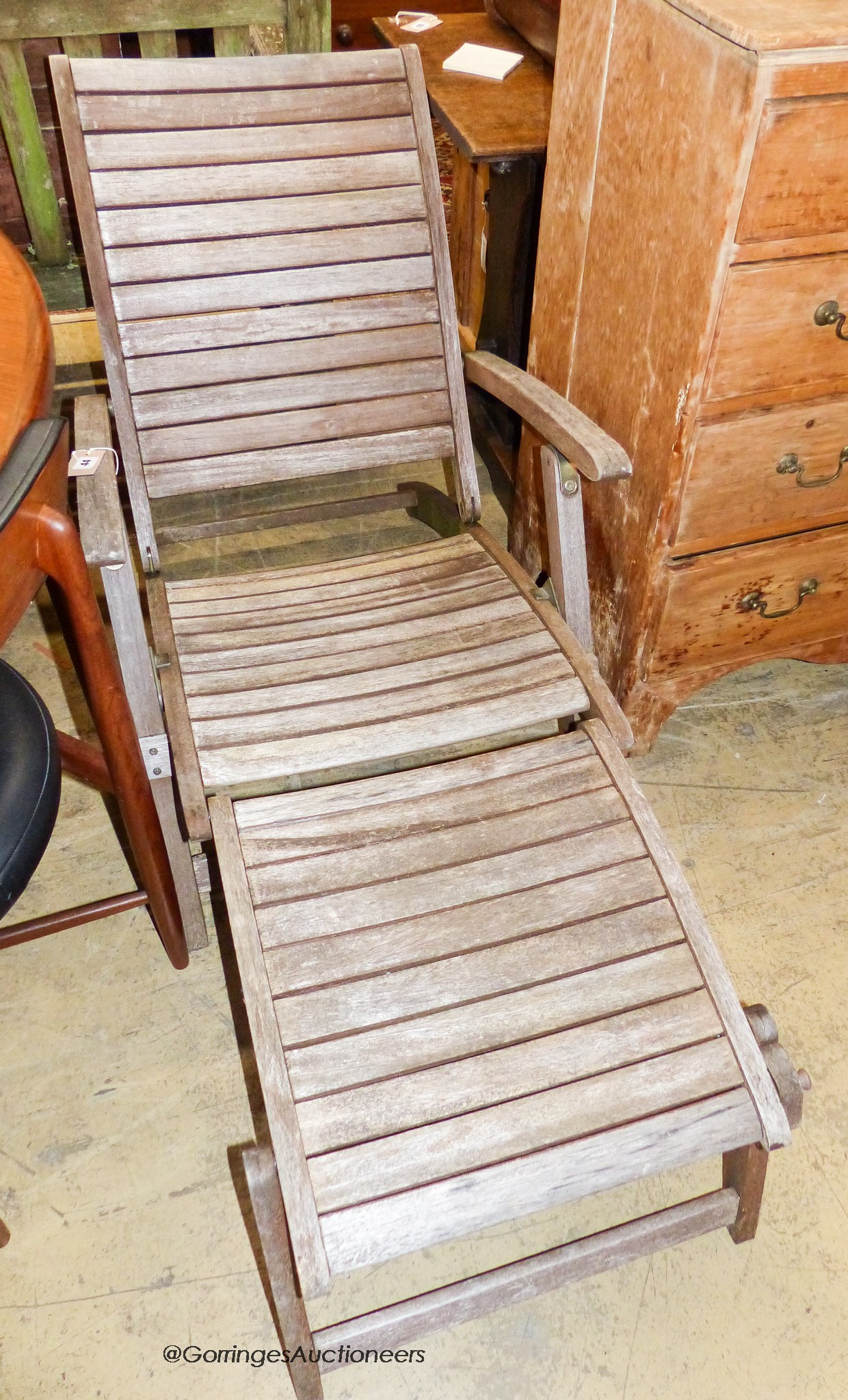 A weathered teak folding garden steamer chair                                                                                                                                                                               