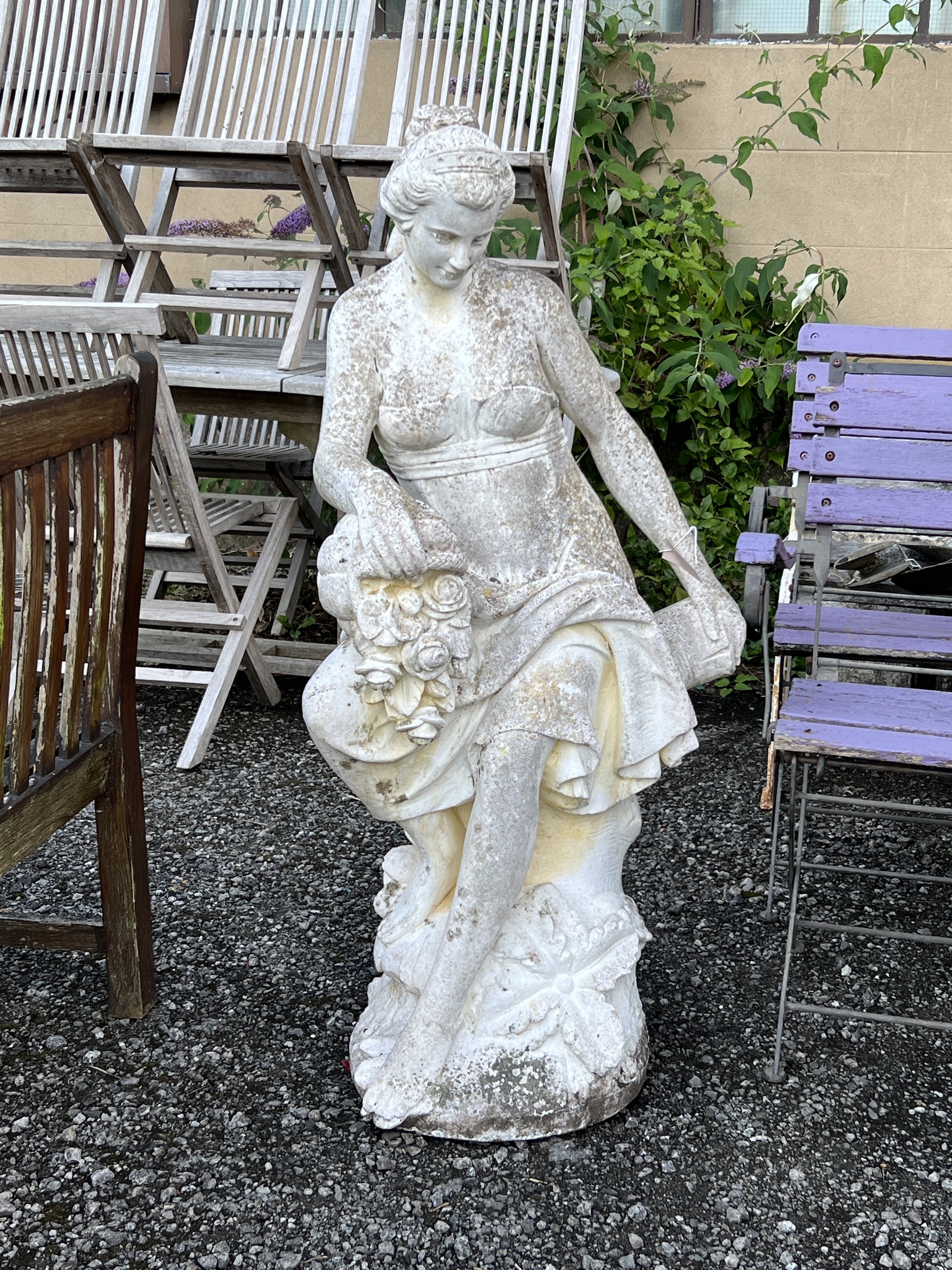 A large reconstituted stone garden statue of a female flower seller, height 120cm                                                                                                                                           