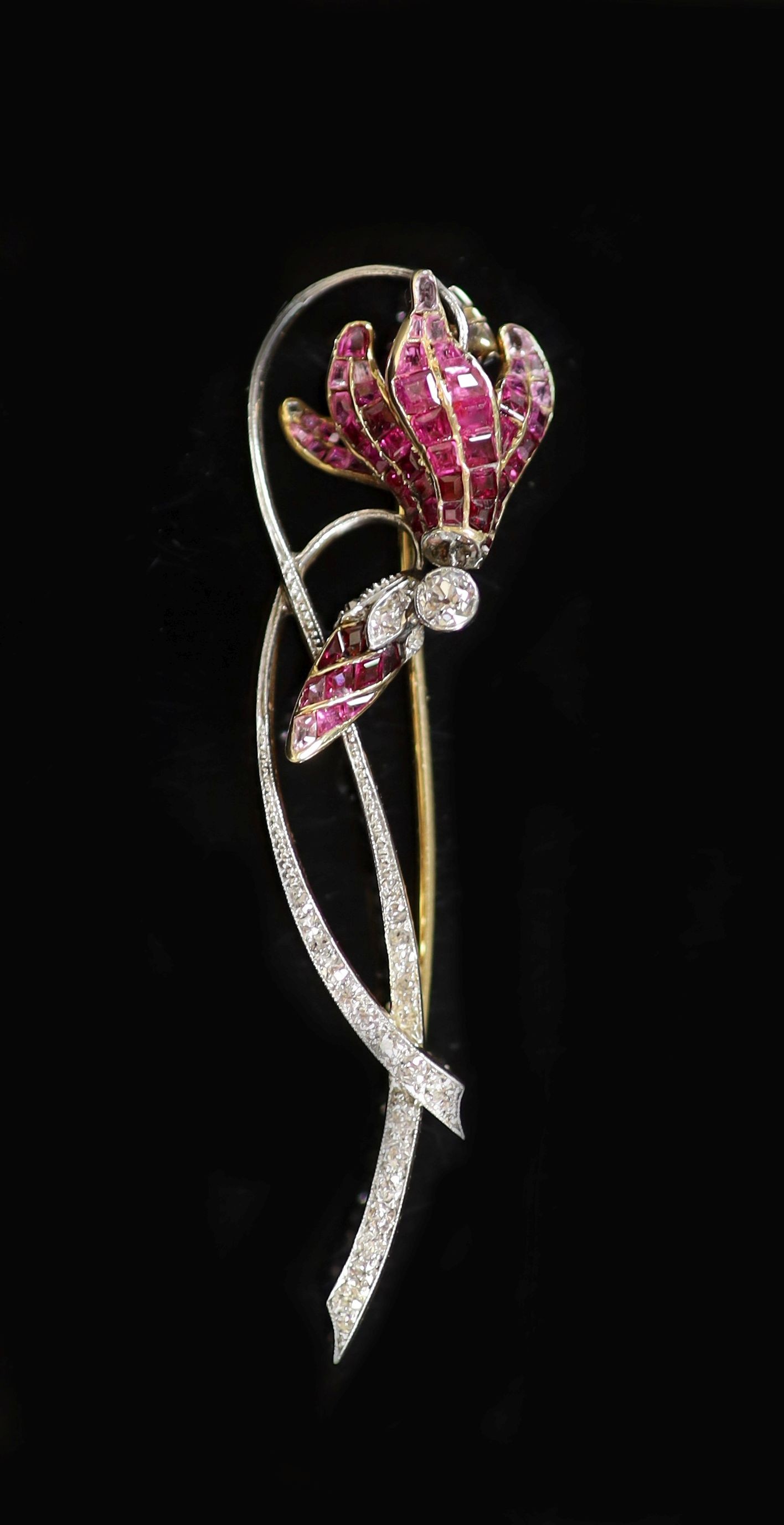 A mid 20th century, gold and platinum graduated ruby and diamond set foliate brooch, in gilt tooled fitted leather case                                                                                                     
