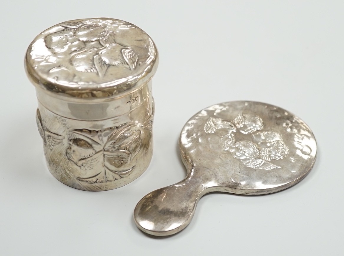 An Edwardian repousse silver Reynolds Angels toilet jar and cover, by William Comyns, London, 1901 and a later similar hand mirror by William Neale Ltd.                                                                    