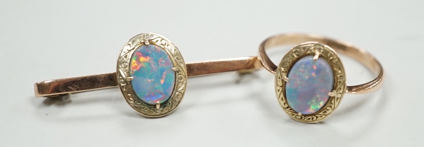 A 9ct and black opal doublet set bar brooch, 38mm and a matching ring, size R, gross weight 5.9 grams.                                                                                                                      