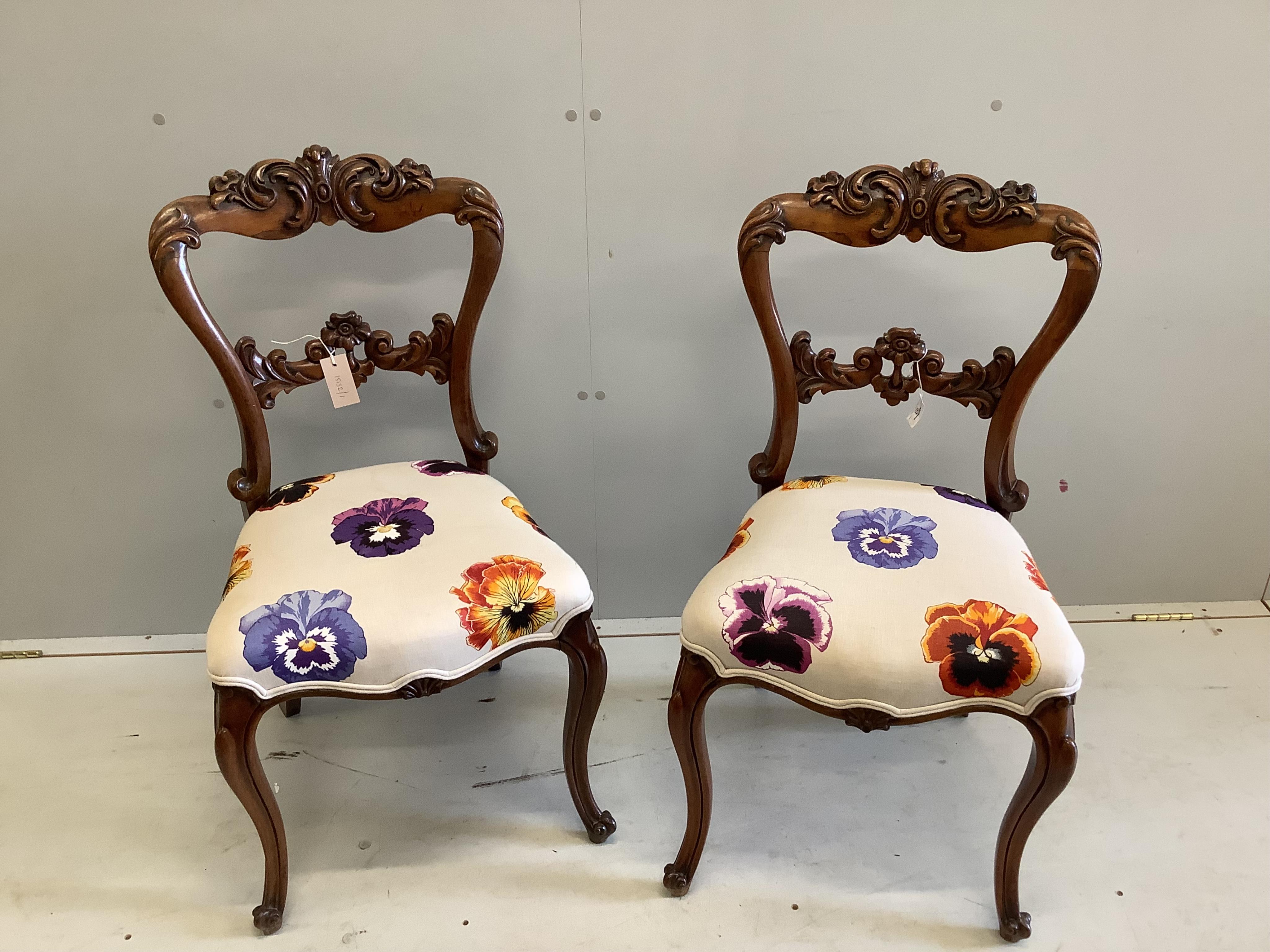 A pair of Victorian carved rosewood dining chairs, height 90cm. Condition - fair to good                                                                                                                                    