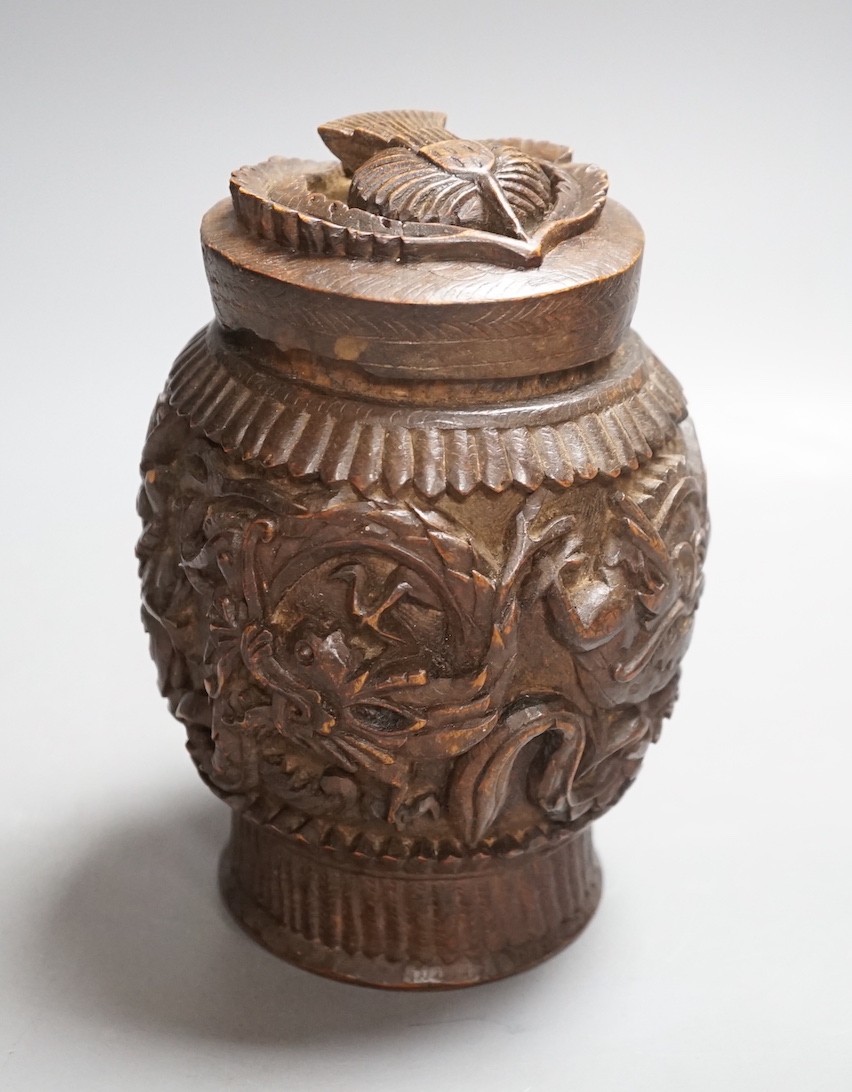 A Burmese carved wooden tobacco jar and cover - 17cm tall                                                                                                                                                                   