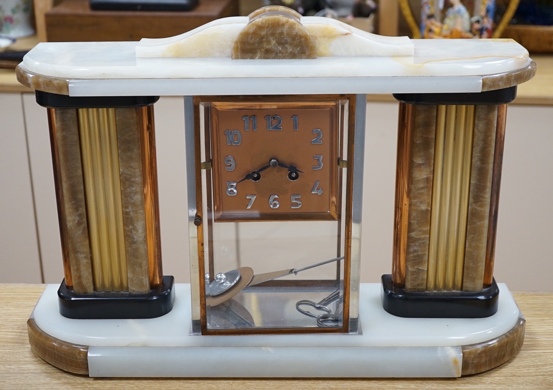 An Art Deco chrome, copper, brass and alabaster four glass mantel clock, 54cms wide                                                                                                                                         