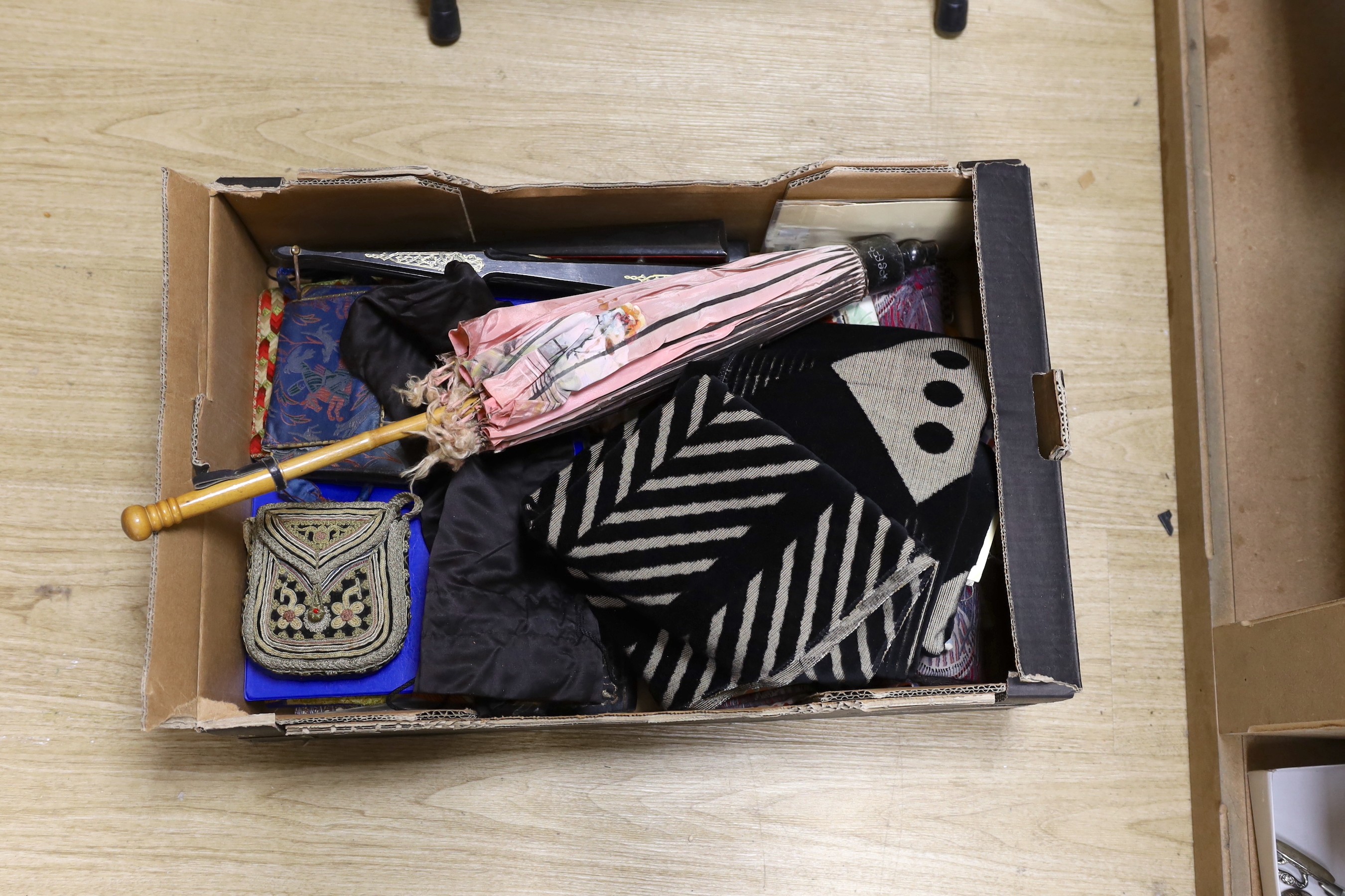 A collection of various fabric samples, fabric bags and a pink parasole                                                                                                                                                     
