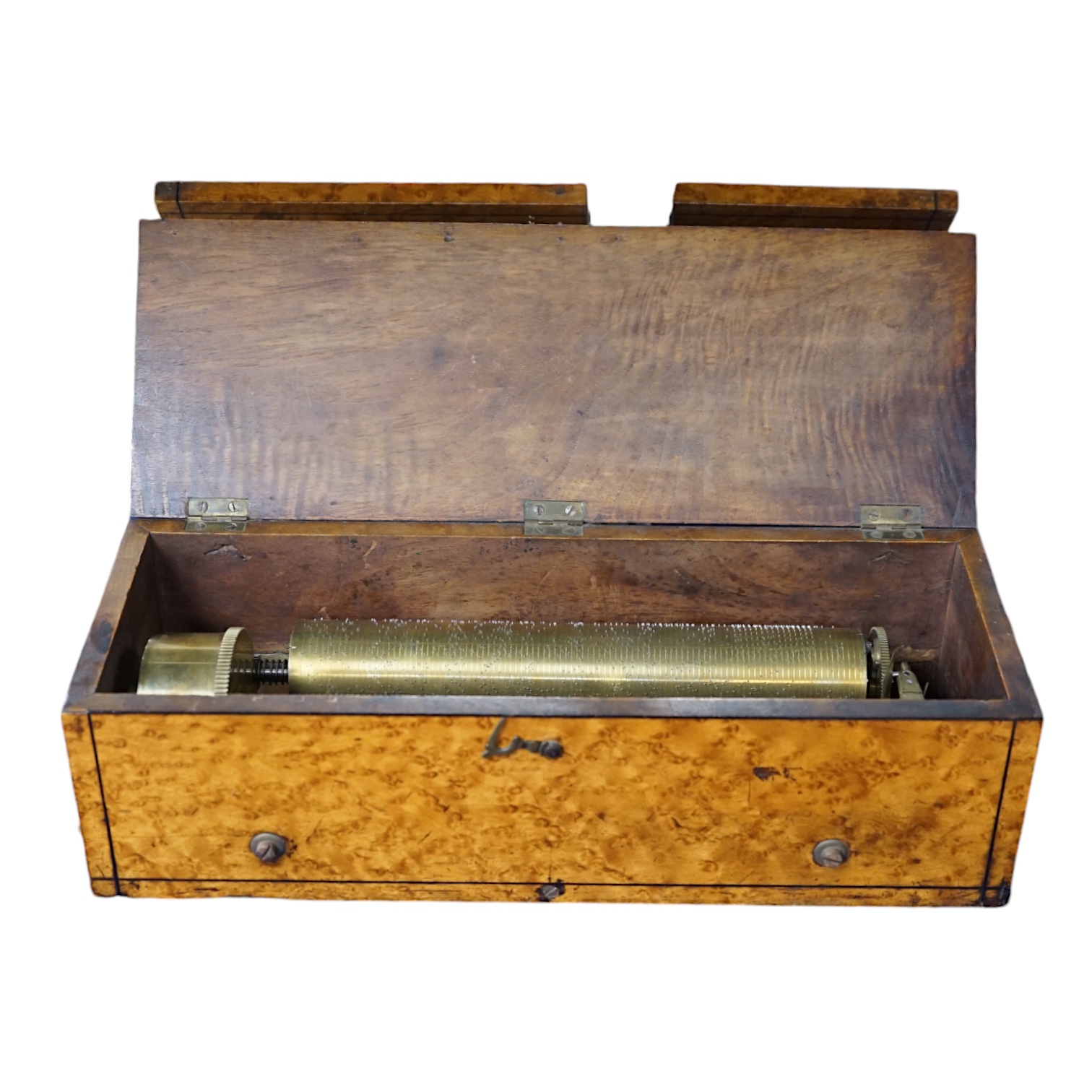 A small mid 19th century Swiss musical box in a bird’s eye maple case, side key wound, 30cm wide. Condition - fair.                                                                                                         