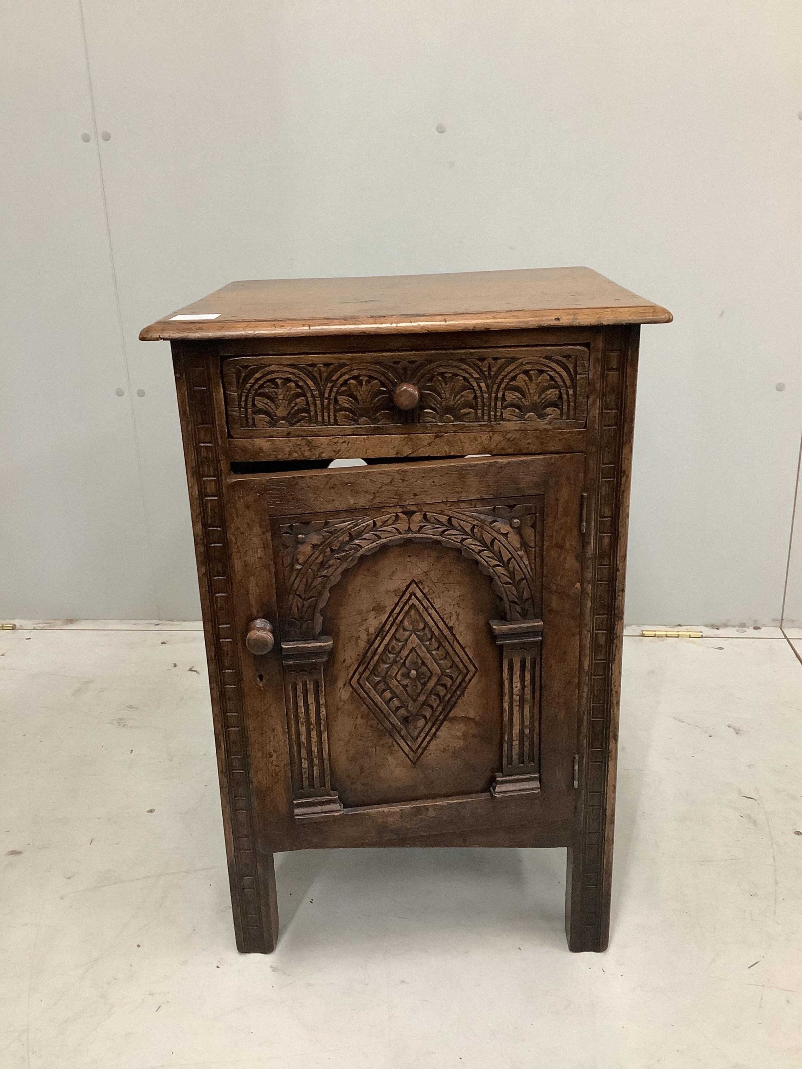 A Tudor style carved oak bedside cupboard, width 47cm, height 71cm. Condition - good                                                                                                                                        