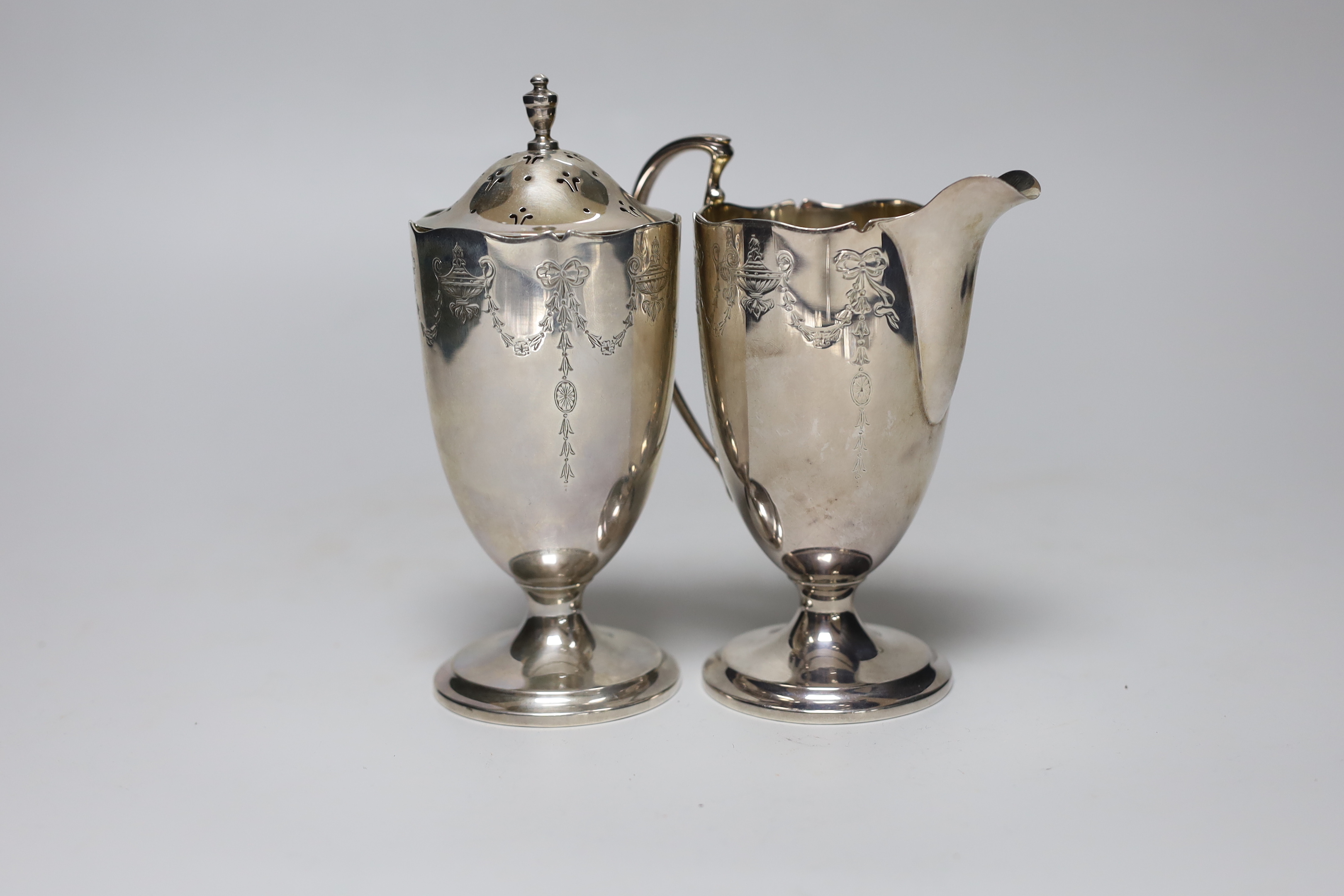 A George V chased silver cream jug and matching sugar caster, Collingwood & Sons Ltd, Birmingham, 1913, caster 15.7cm, 12.2 oz.                                                                                             