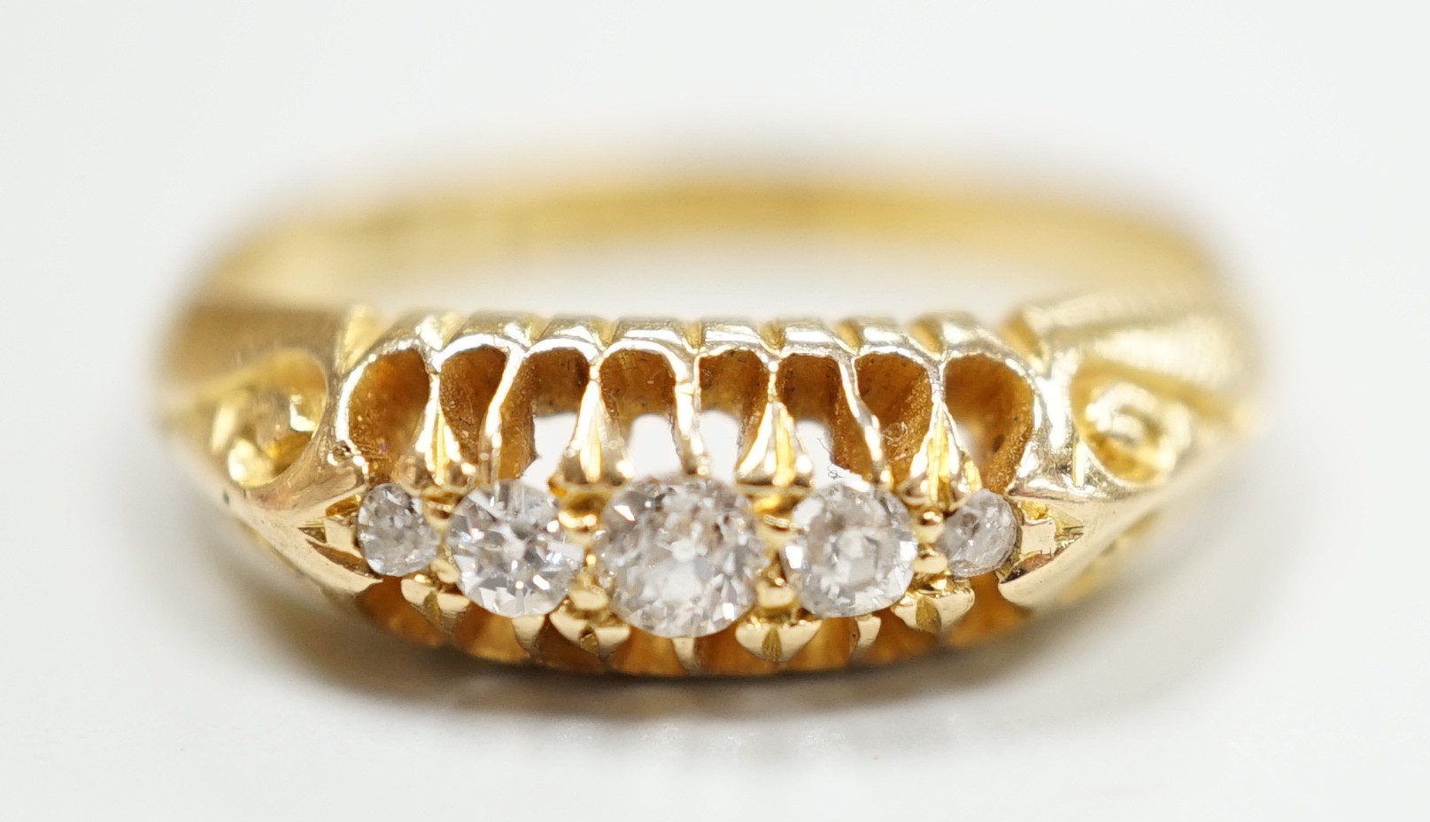 An early 20th century 18ct gold and graduated five stone diamond chip set ring, size L, gross weight 3.6 grams.                                                                                                             