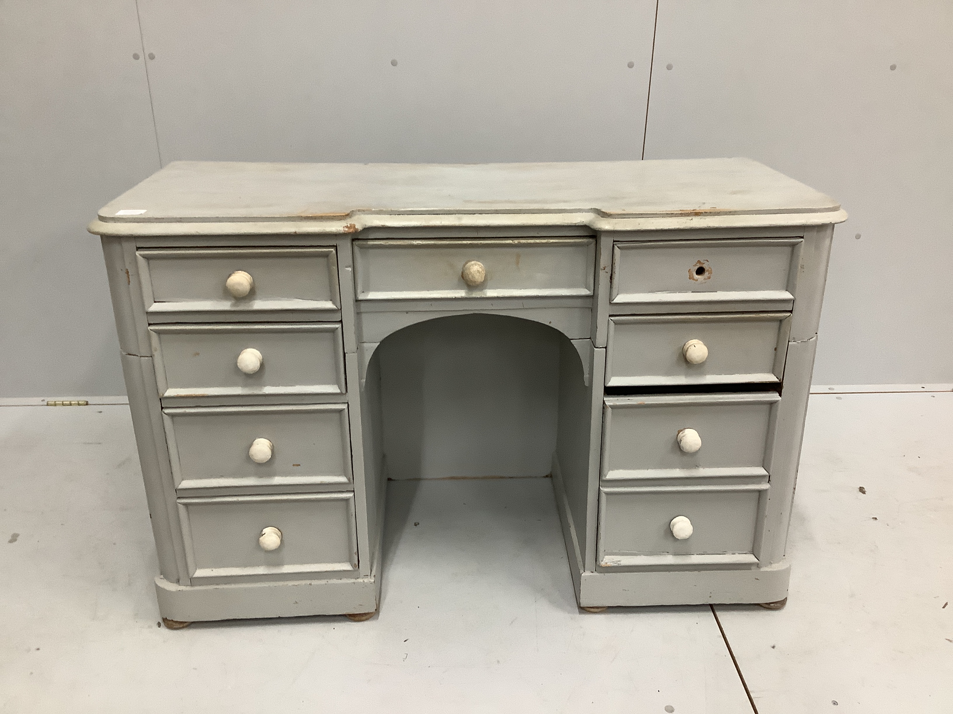 A Victorian pine inverse breakfront kneehole dressing table, cut and later painted, width 122cm, depth 50cm, height 78cm                                                                                                    