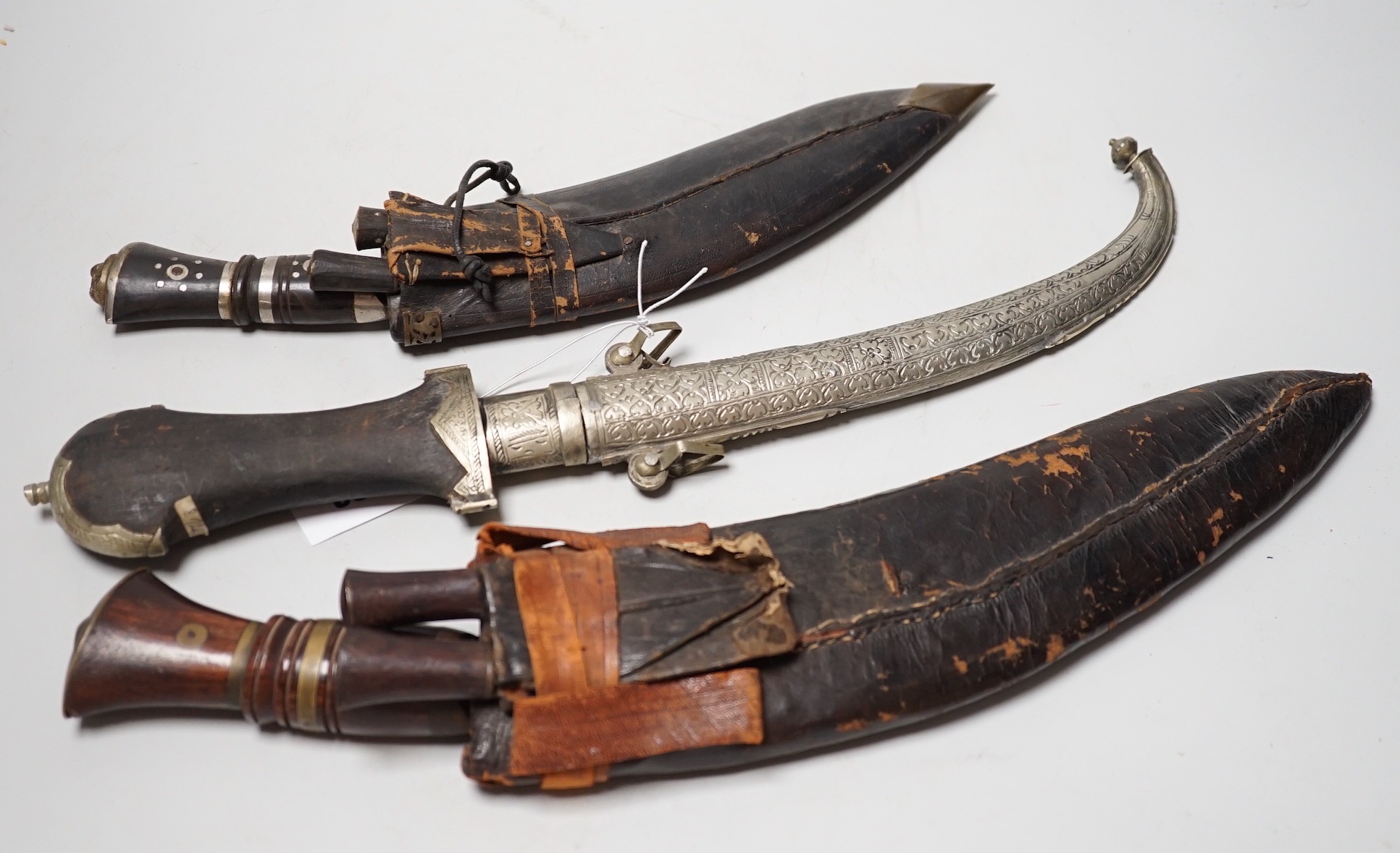 Two Kukri and eastern daggers, within engraved sheath, (3)                                                                                                                                                                  