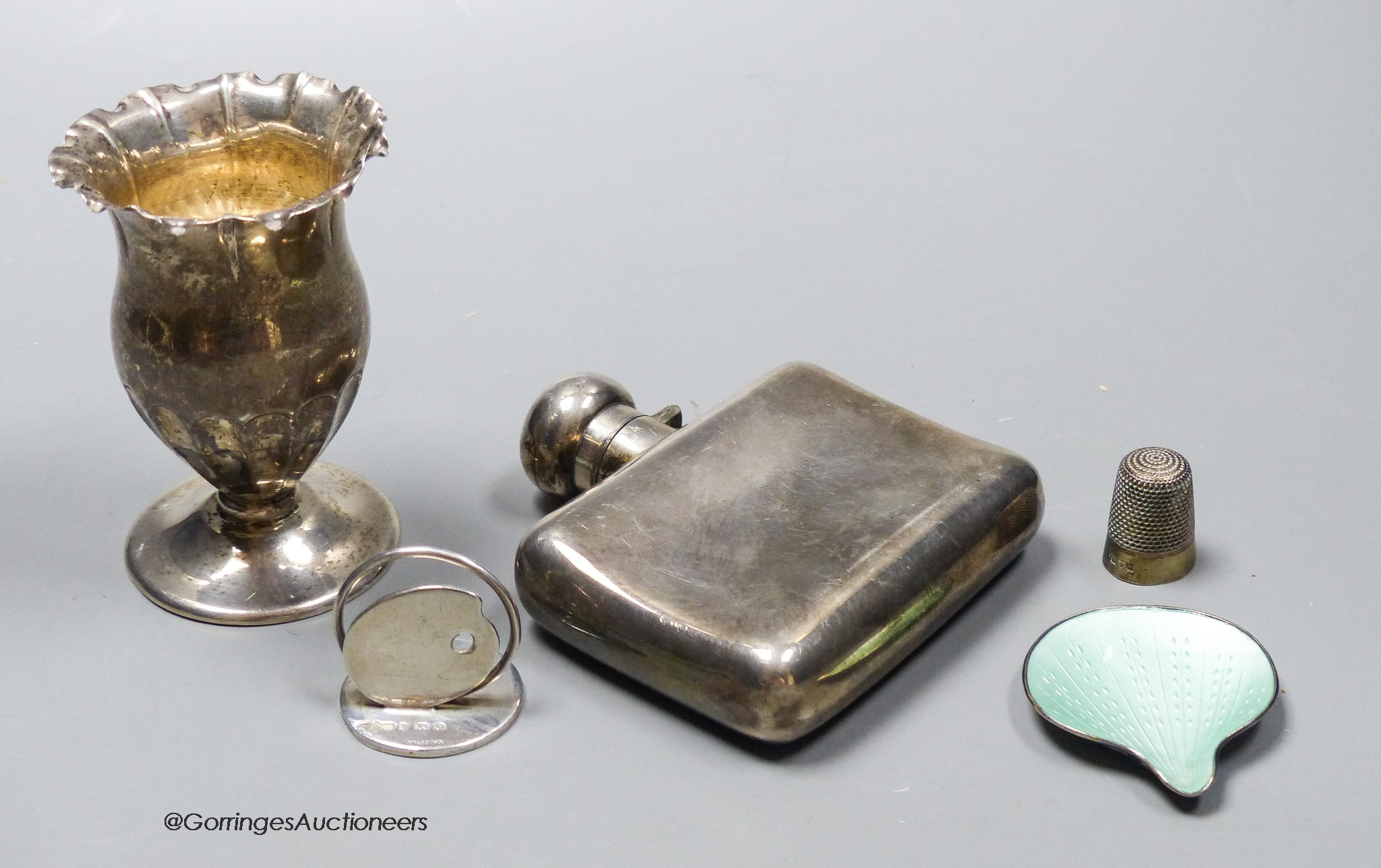 A George V silver hip flask, width 85mm, a small silver vase, a silver menu holder, a silver thimble and a Norwegian sterling and enamel small dish, gross 6oz.                                                             