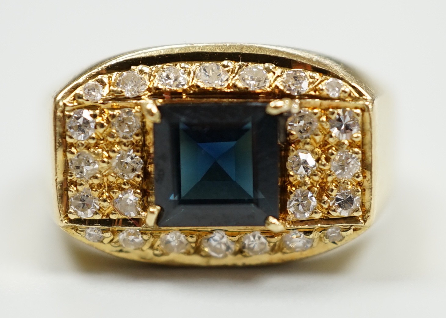 A modern 750 yellow metal, single stone sapphire and pave set diamond dress ring, size O, gross weight 5.9 grams.                                                                                                           