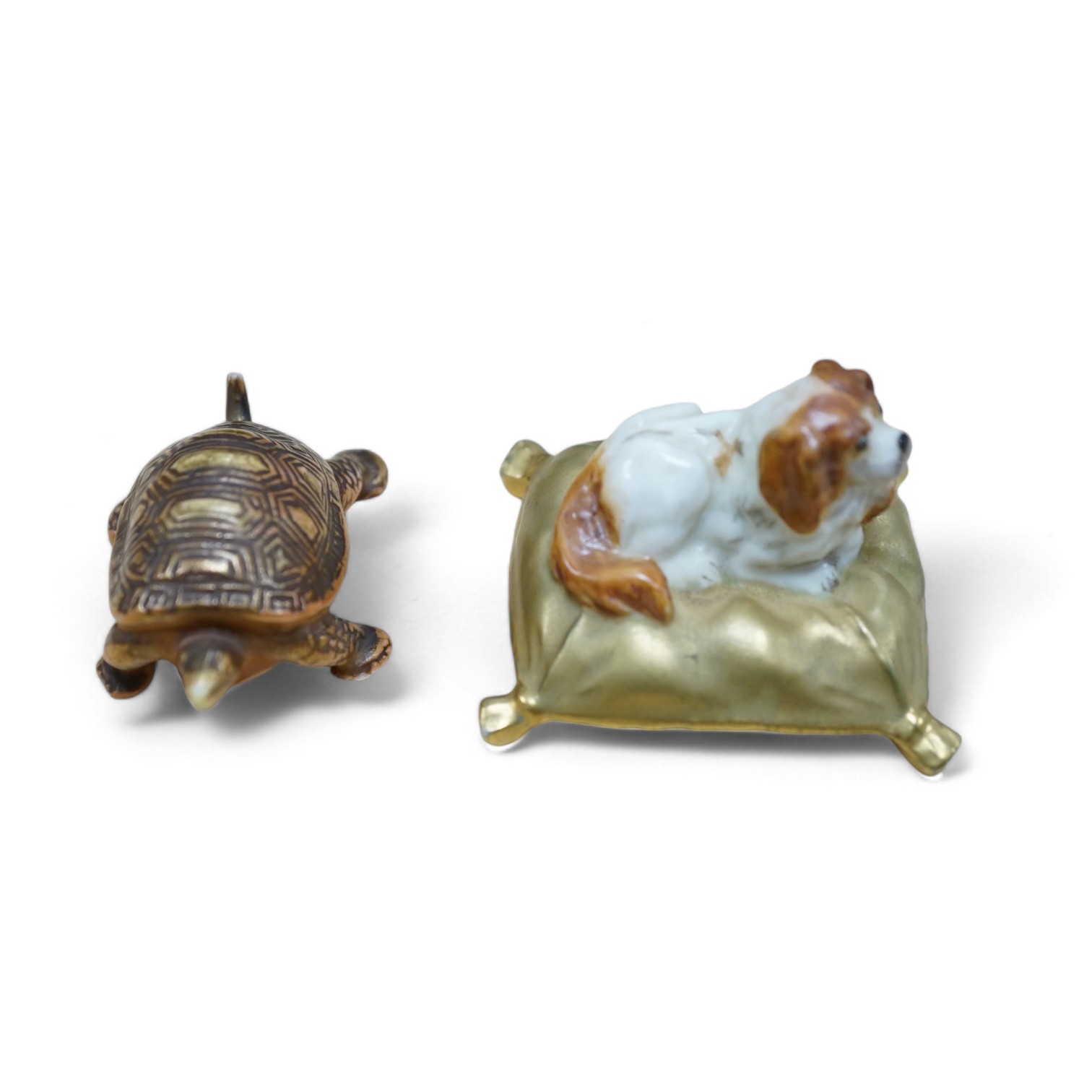 An unusual Royal Worcester miniature King Charles Spaniel sitting on cushion and tortoise, 4cm wide. Condition - fair                                                                                                       