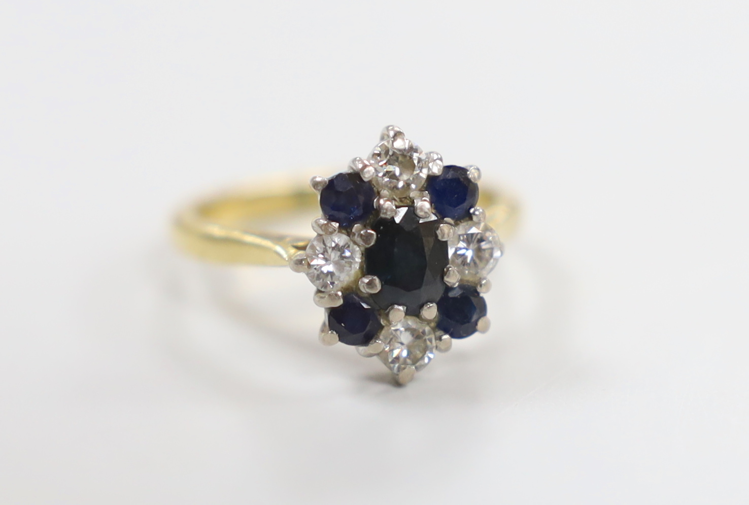 A modern 18ct gold, sapphire and diamond cluster set ring, size M, gross weight 4.4 grams.                                                                                                                                  