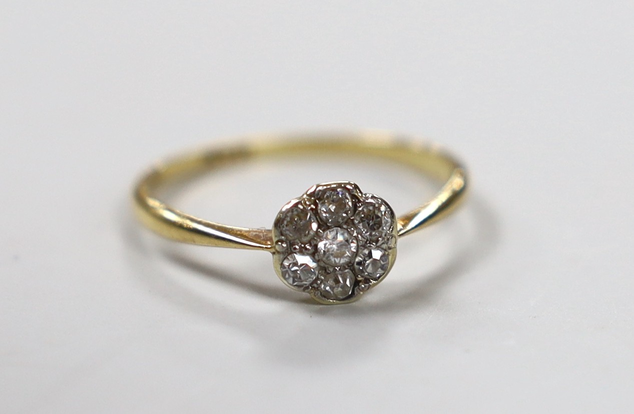 An 18ct and diamond cluster ring, size L/M, gross weight 1.4 grams.                                                                                                                                                         