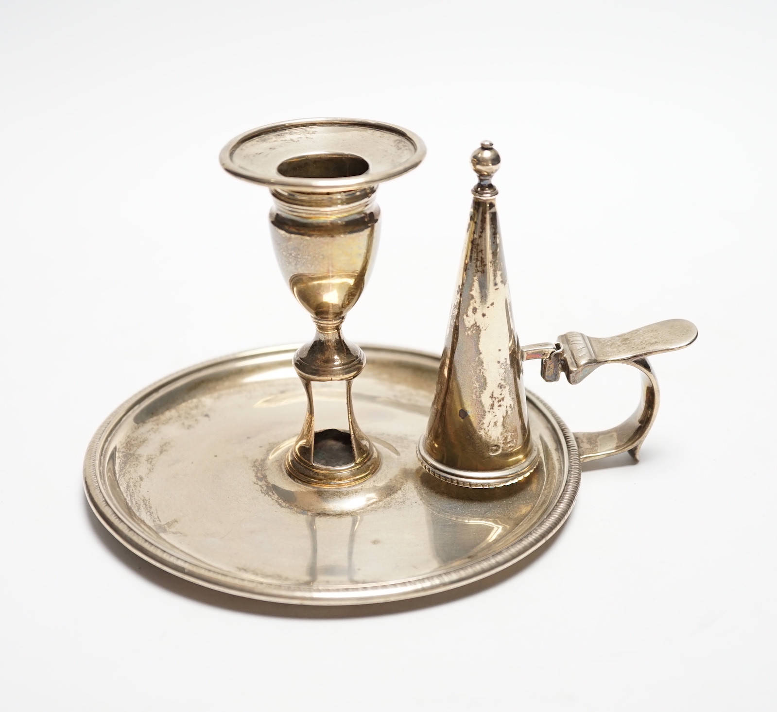 A George III silver chamberstick, John Mewburn, London, 1801, with extinguisher(marks rubbed), diameter 13.7cm, 9.7oz.                                                                                                      