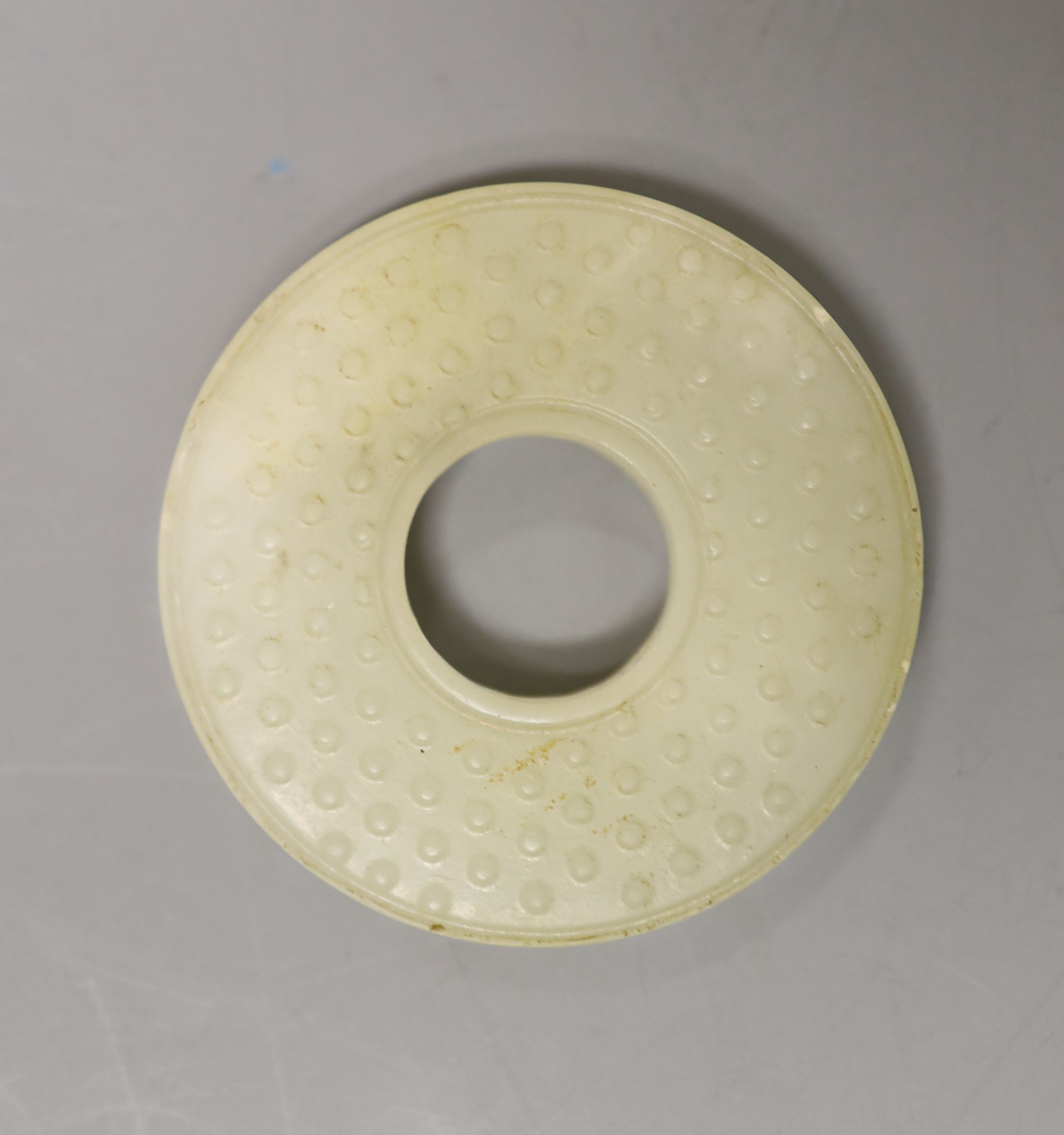 A Chinese pale celadon jade bi disc, 6cm diameter                                                                                                                                                                           