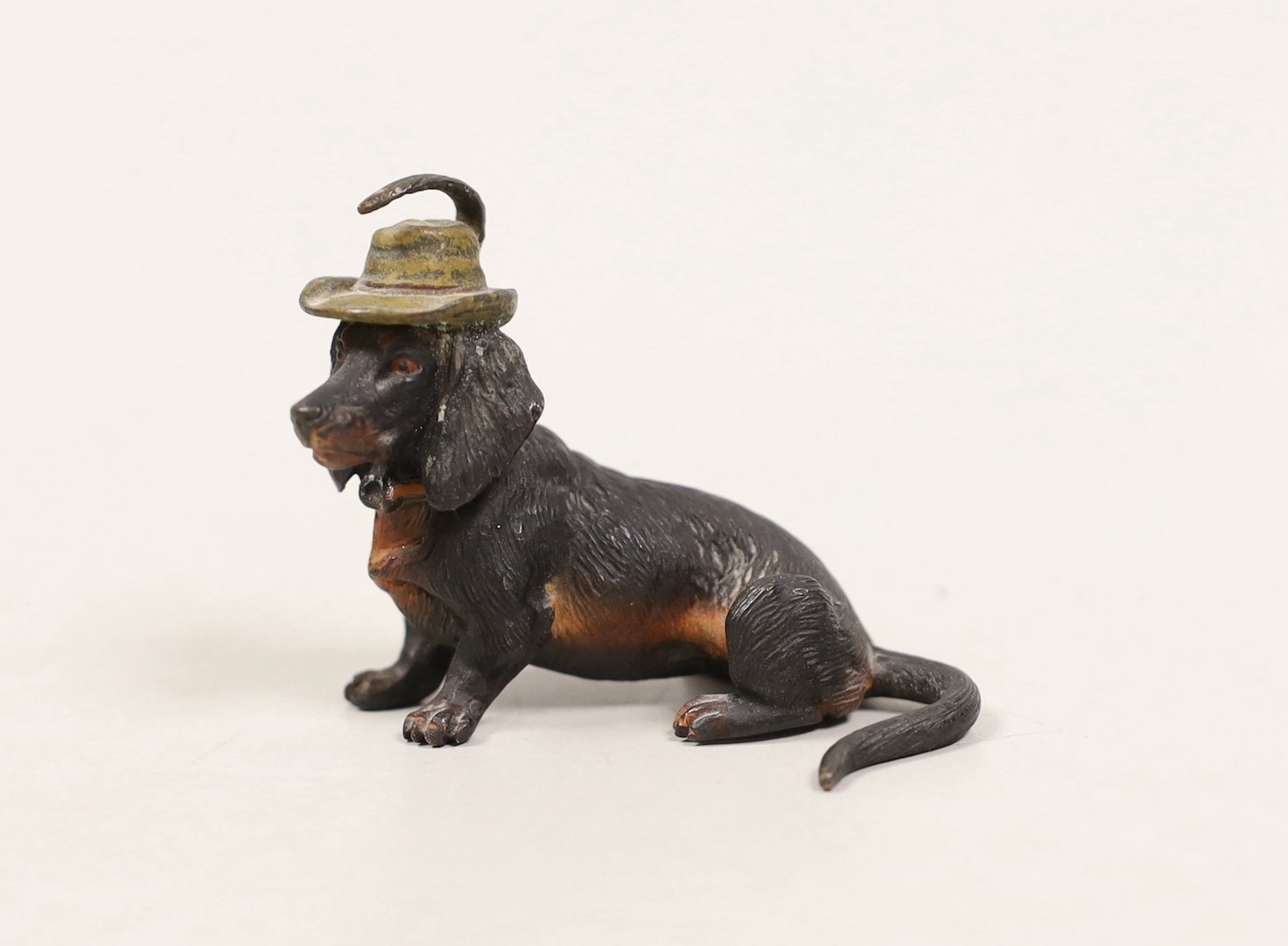 An Austrian cold painted bronze of a seated Dachshund wearing a hat                                                                                                                                                         