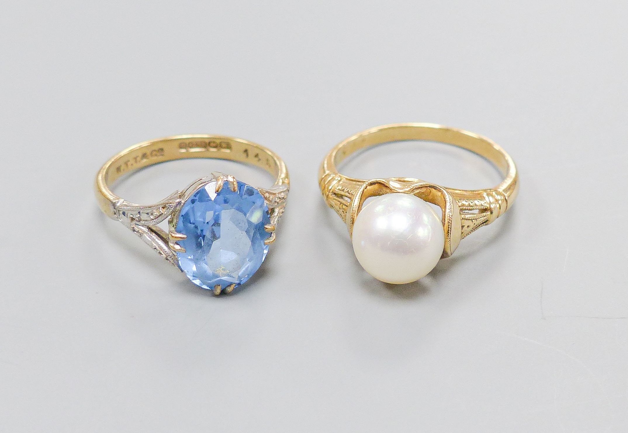 A 14K ring set with a cultured pearl in a fancy mount, size O, gross 4 grams and a 9ct gold dress ring set with an oval blue stone, 3.4 grams.                                                                              