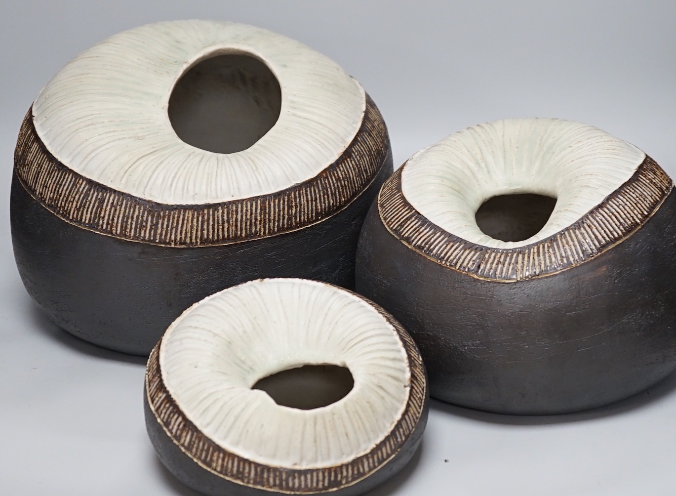 Ruth Sulke - a set of three graduated shell-like circular pottery vases, each inscribed R/S on base, tallest approximately 25cms high                                                                                       