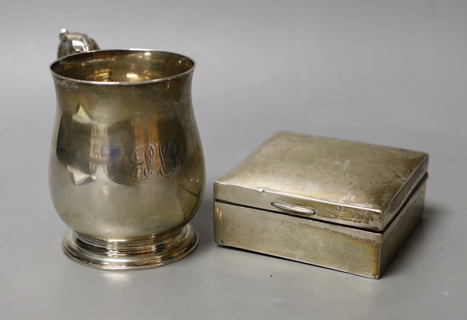 A George V silver christening mug, London, 1934, 95mm and a silver mounted cigarette box.                                                                                                                                   