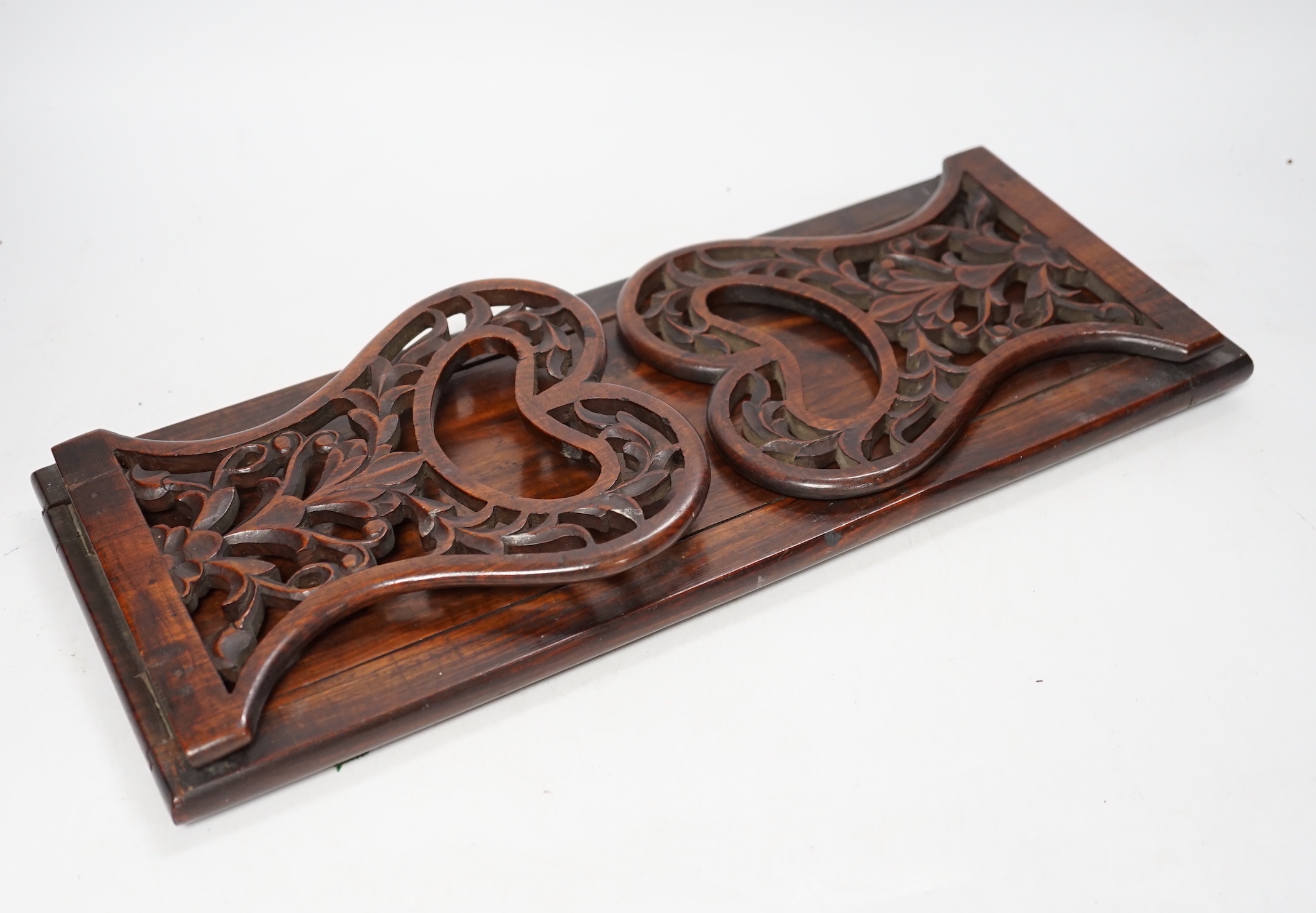 A 19th century rosewood book slide with fretted sides, base 39cm wide                                                                                                                                                       