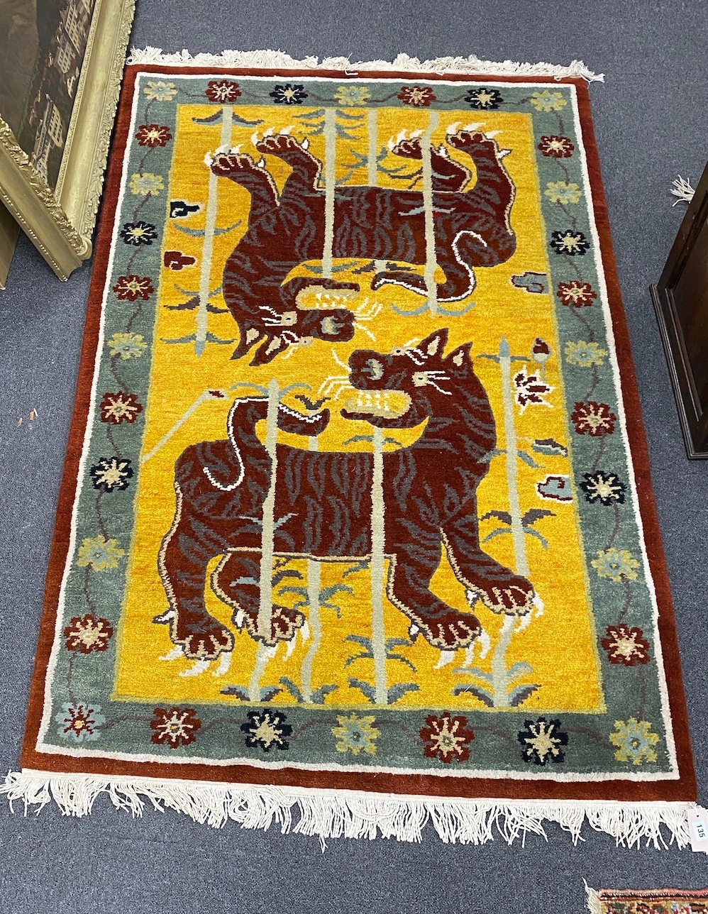 A Tibetan wool gold ground rug with twin tiger motif, 186 x 124cm                                                                                                                                                           