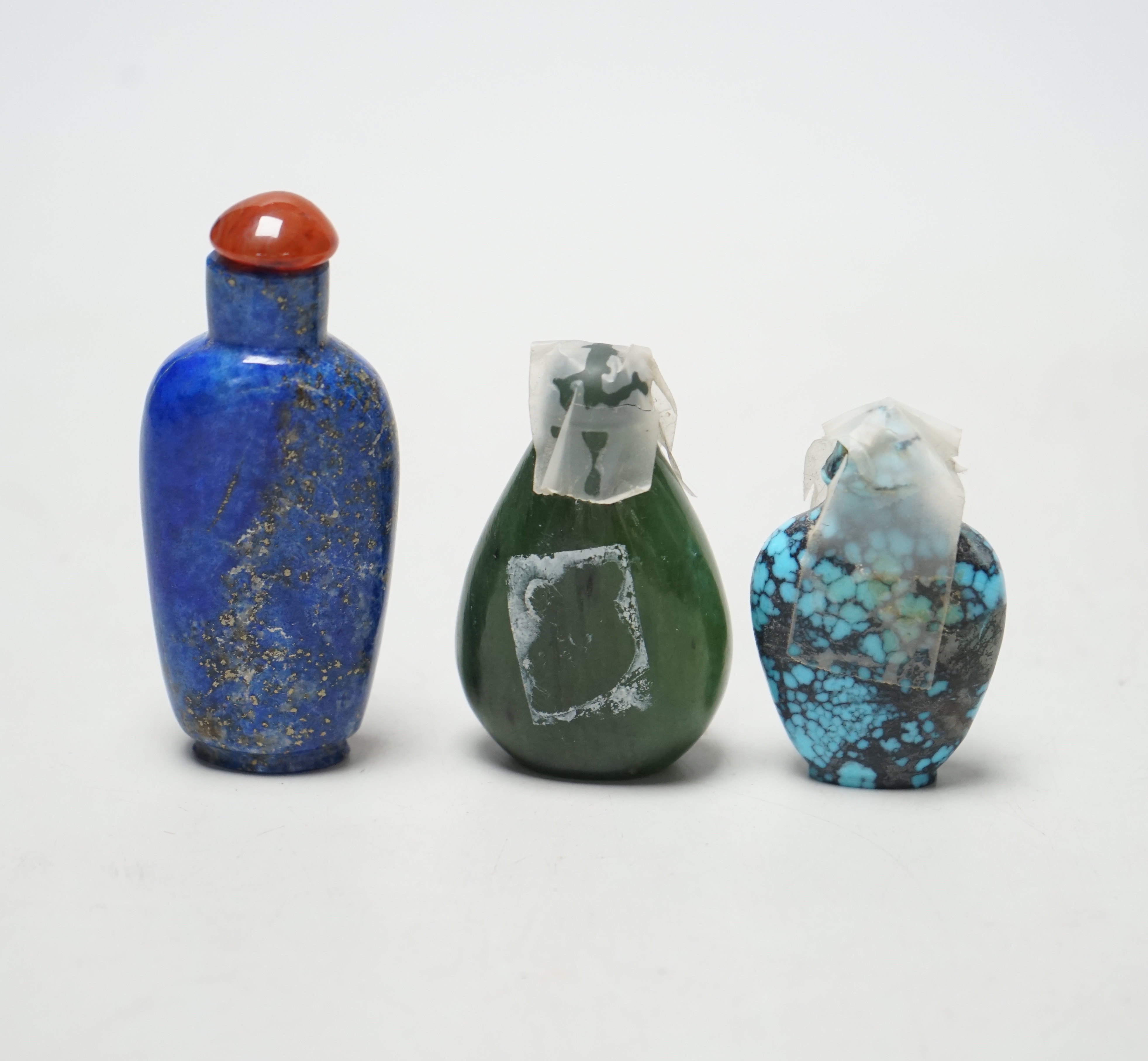 Thee Chinese hardstone snuff bottles, in spinach green Jade, lapis lazuli and turquoise matrix, tallest 7.4cm                                                                                                               