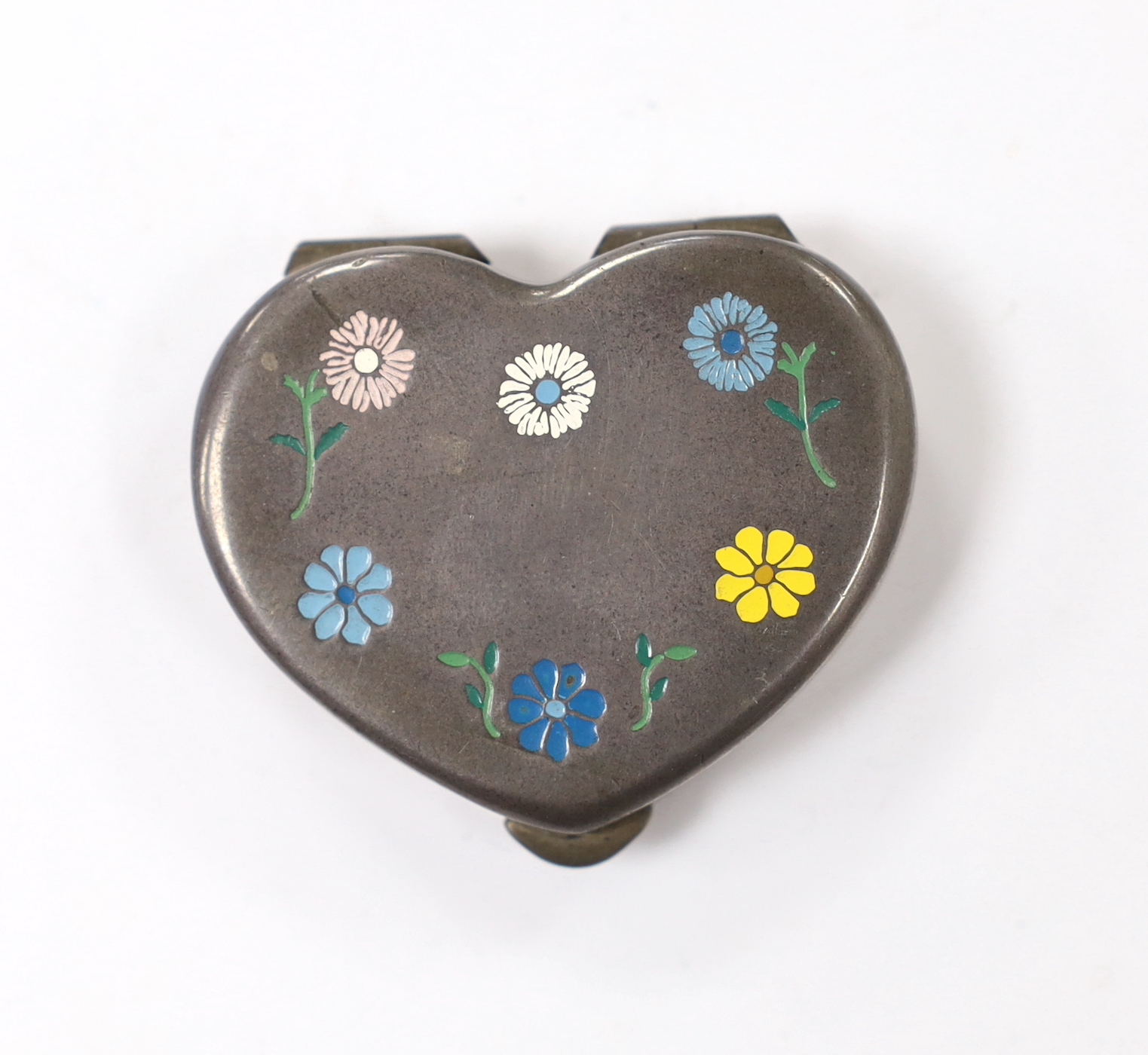 A 20th century Cartier sterling and enamel heart shaped pill box, decorated with flower heads, width 41mm.                                                                                                                  