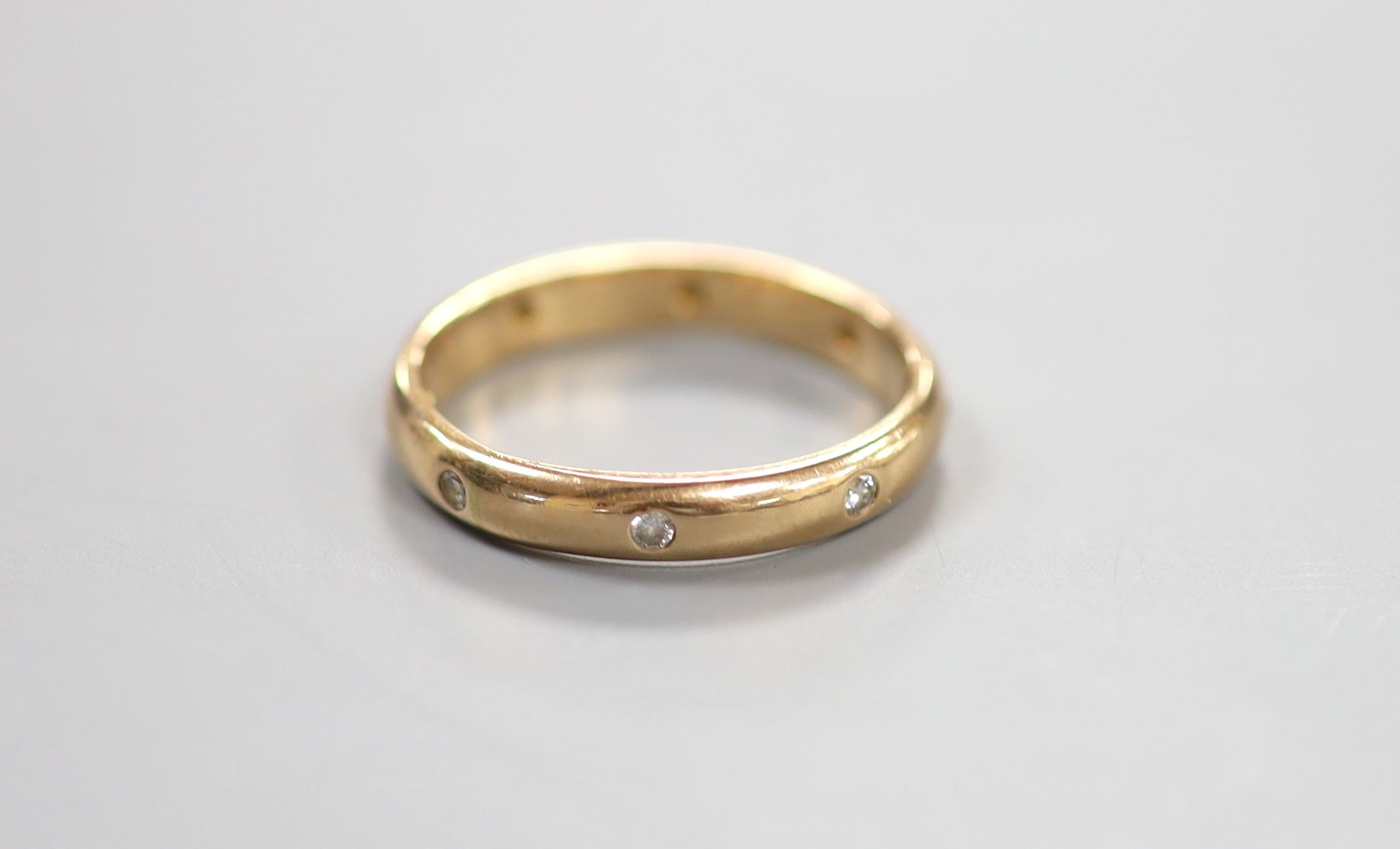 A modern 14k and gypsy set eight stone diamond eternity ring, size R/S, gross 4.3 grams.                                                                                                                                    