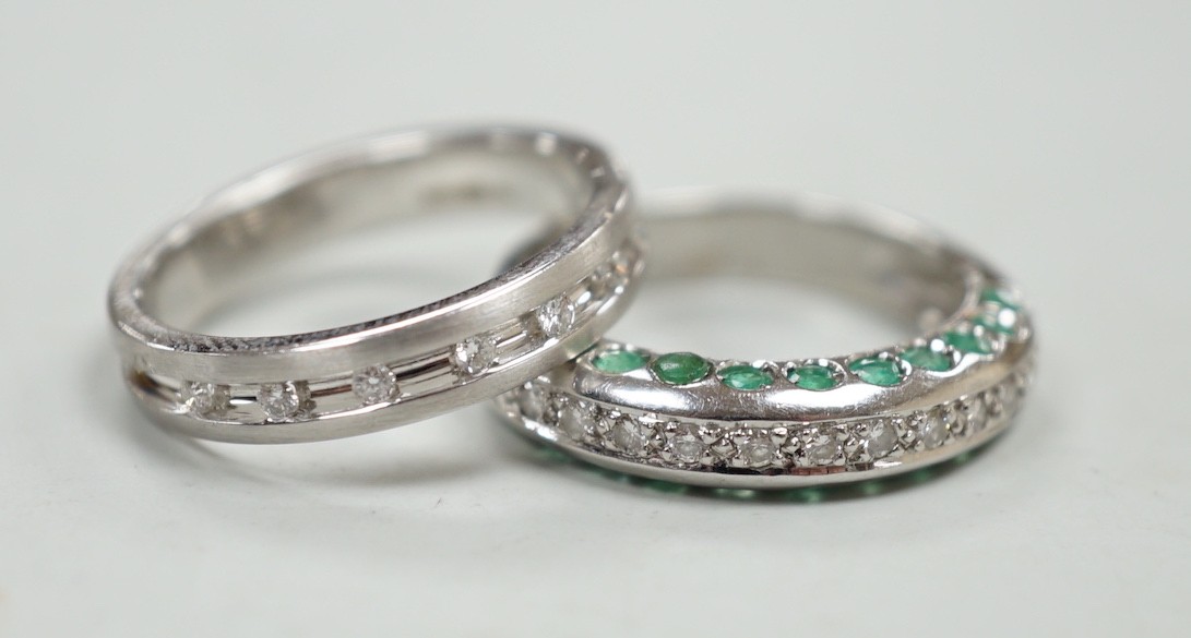 An unusual modern 18ct white gold and thirteen stone diamond chip set half hoop ring, each side of the settling set with ten emeralds, size L and one other modern 18ct white gold and diamond chip set ring, size N, gross 