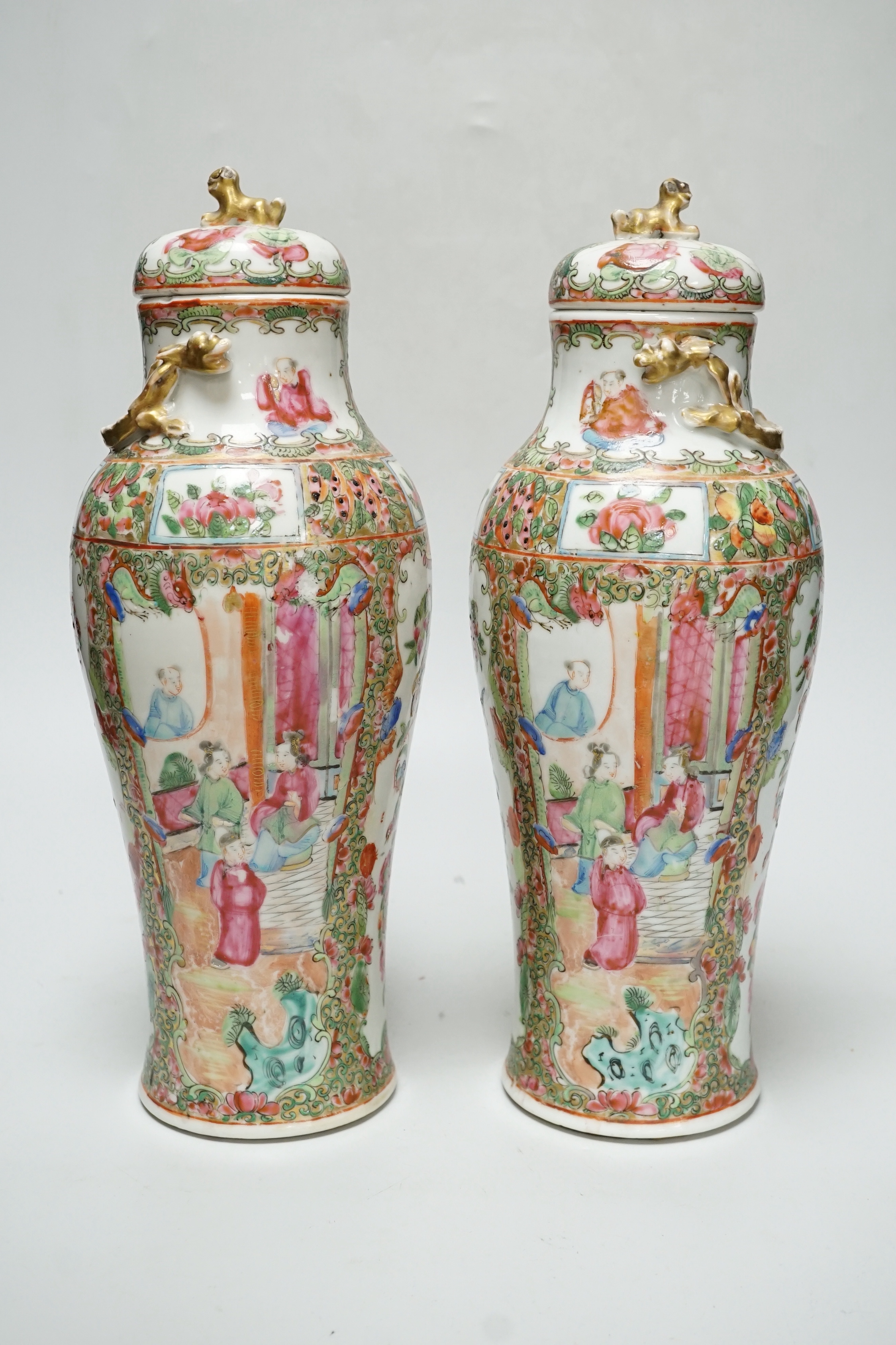 A pair of Chinese famille rose Canton baluster jars and covers with lion dog finials, 32cm high                                                                                                                             