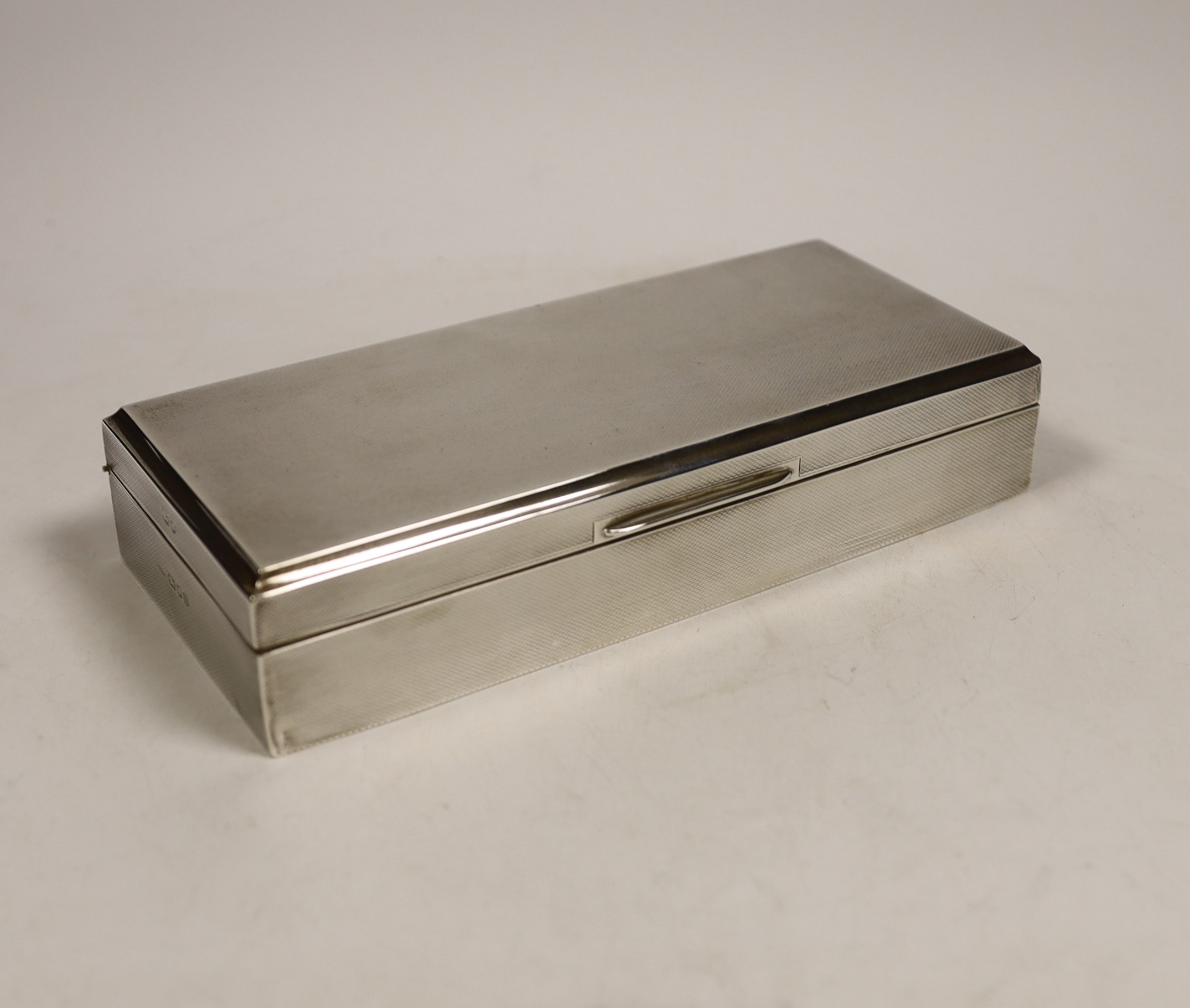 A George VI engine turned silver mounted rectangular cigarette box, Asprey & Co Ltd, London, 1937, 20.3cm.                                                                                                                  