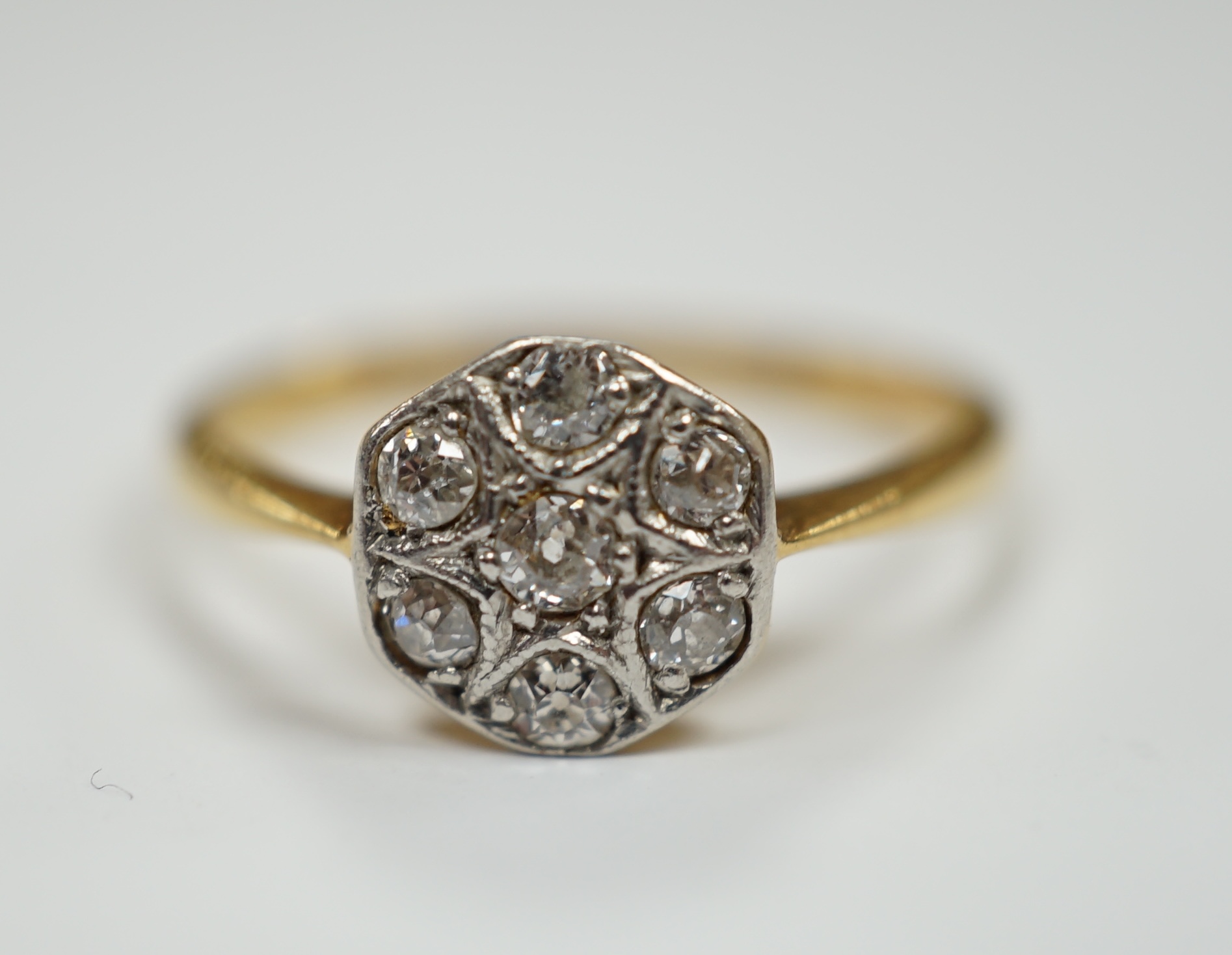 A 1920's 18ct, plat and seven stone diamond set cluster ring, size K, gross weight 2.2 grams.                                                                                                                               