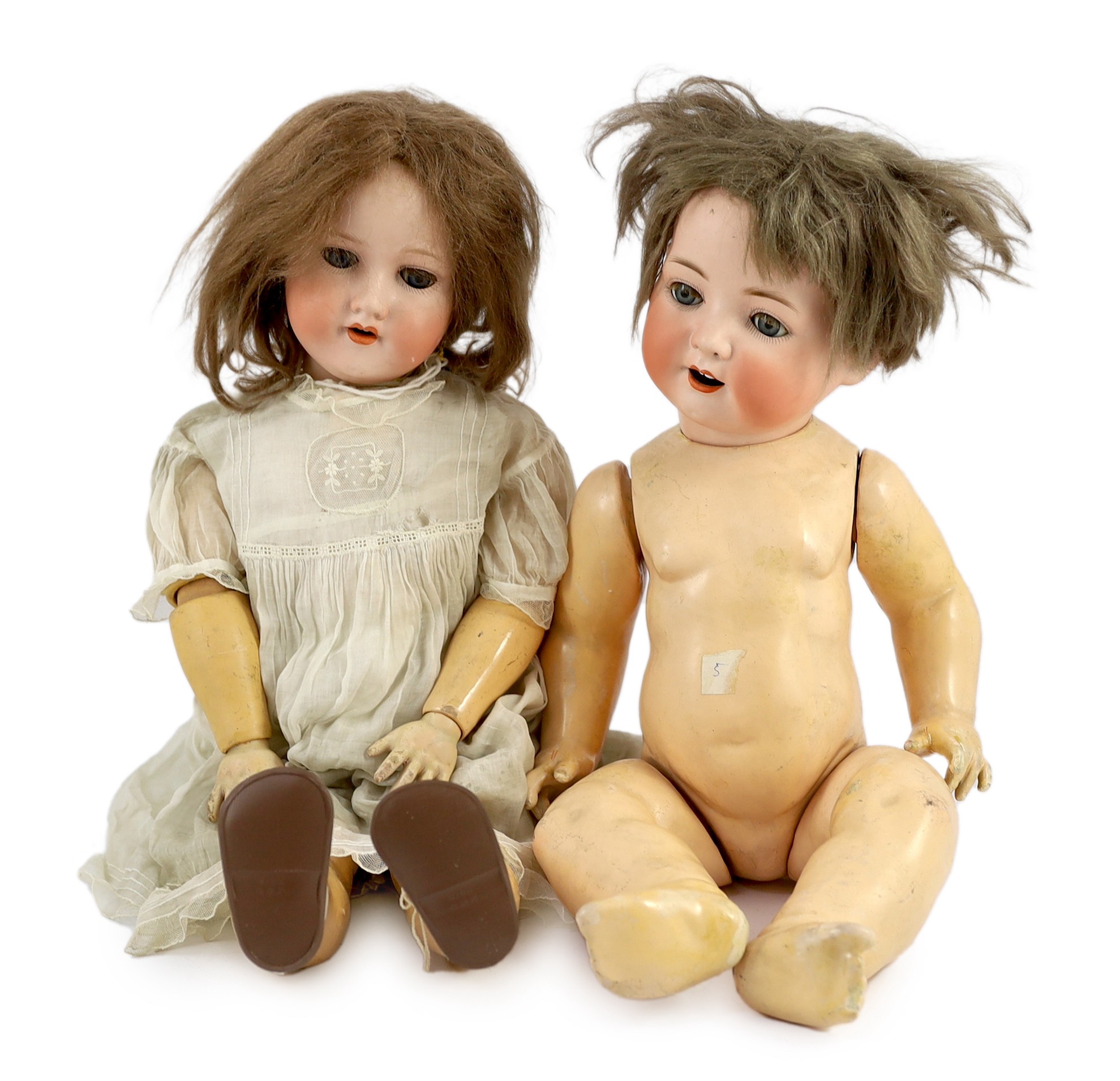 An Armand Marseille bisque doll, German, circa 1912, 24in. and 21in. resp.                                                                                                                                                  
